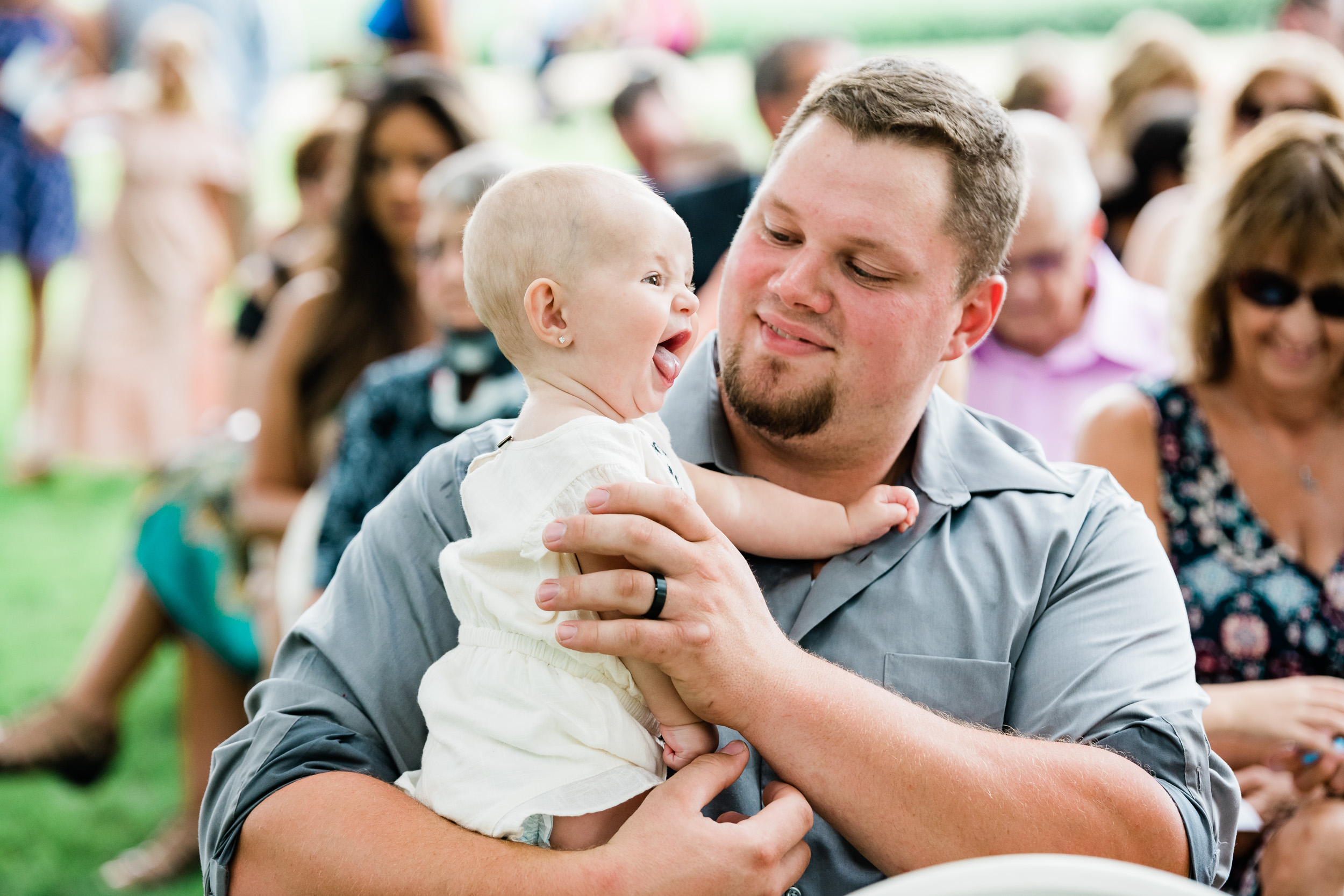 Baby smiling in man's arms