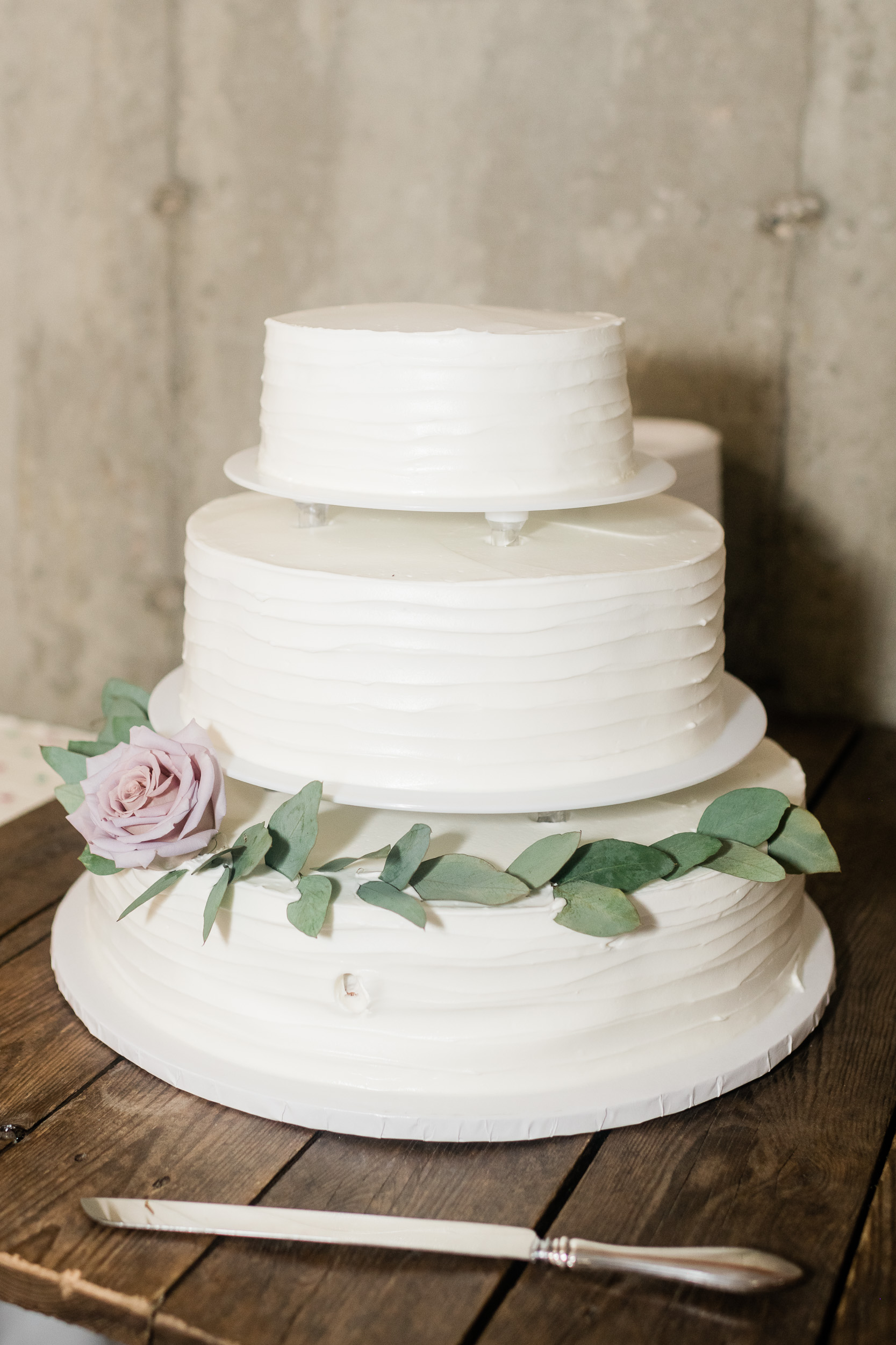 Wedding cake with white frosting and greenery