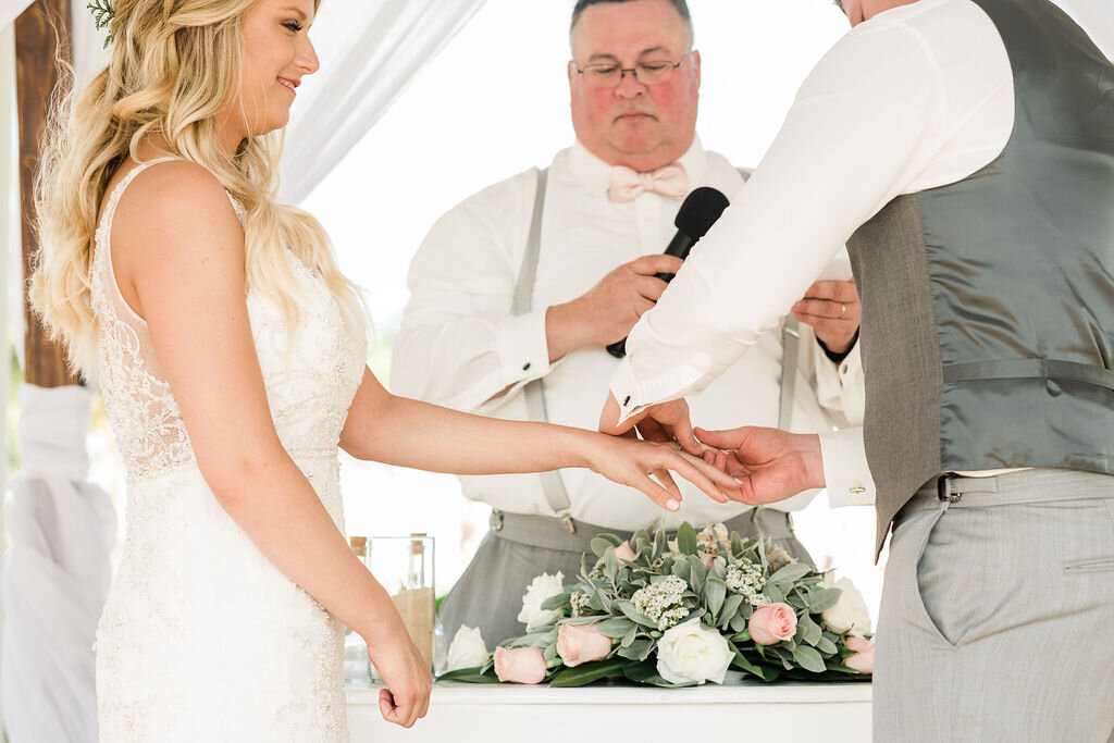 Groom putting ring on bride's finger