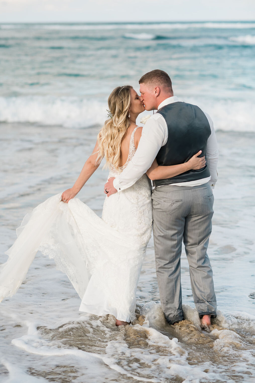Bride and groom kissing in the ocean