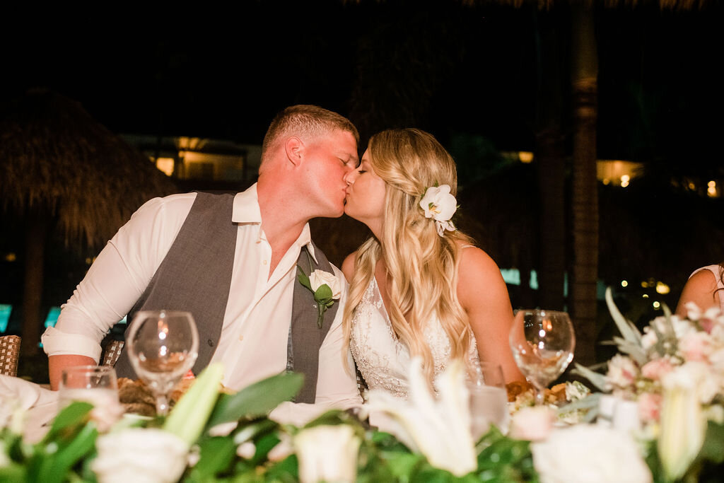 Bride and groom kissing at their table