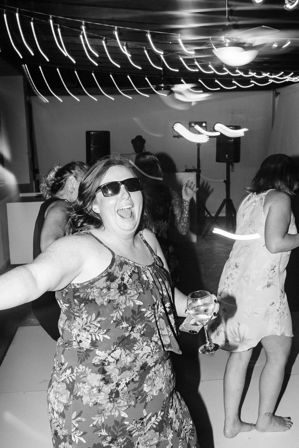 Wedding guest dancing while wearing sunglasses