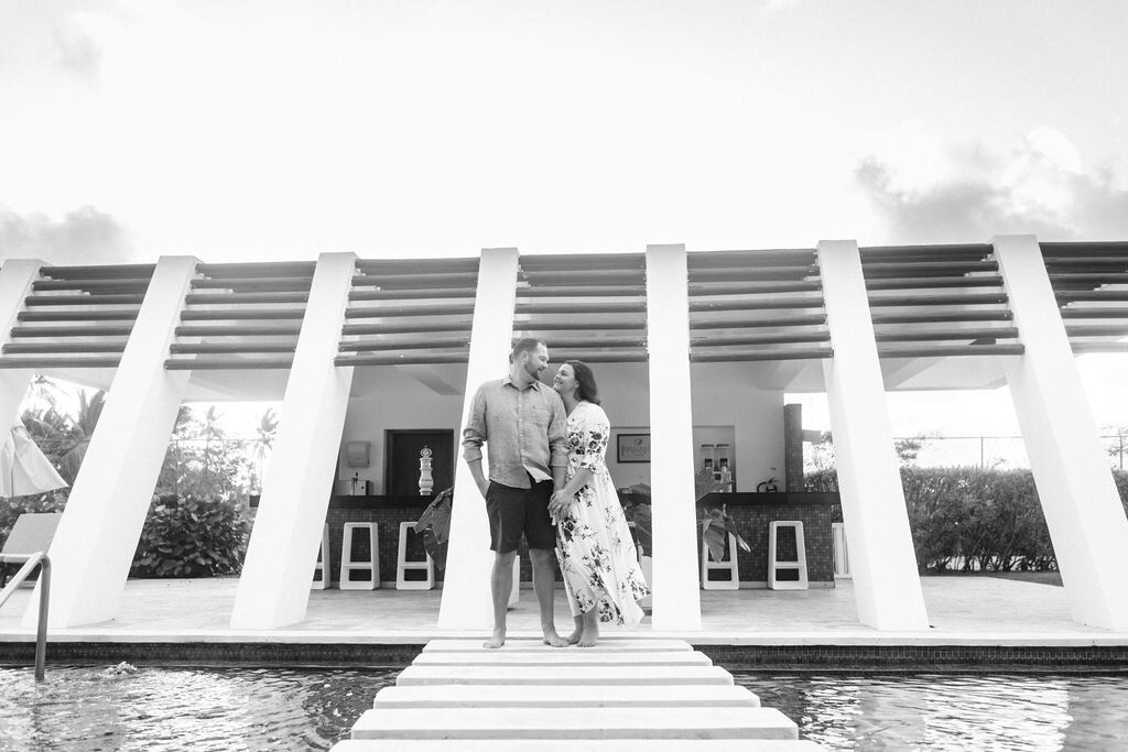 Engaged couple standing in front of building with white pillars