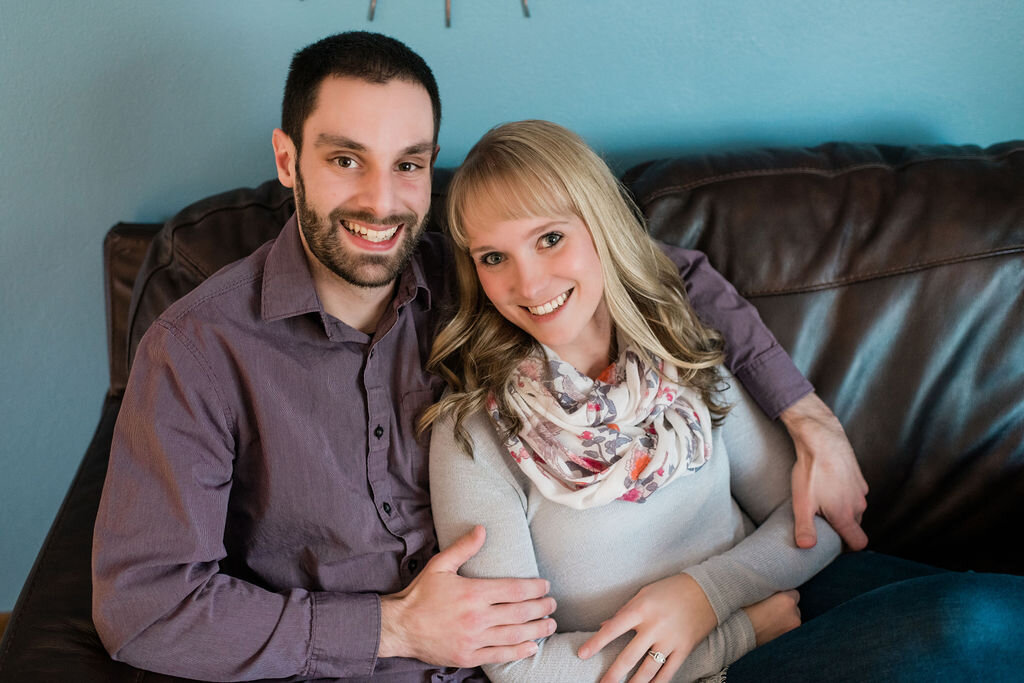 Engaged couple smiling on the couch