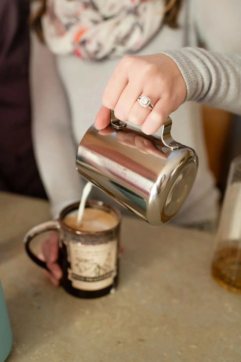 Woman pouring foamed milk into a mug