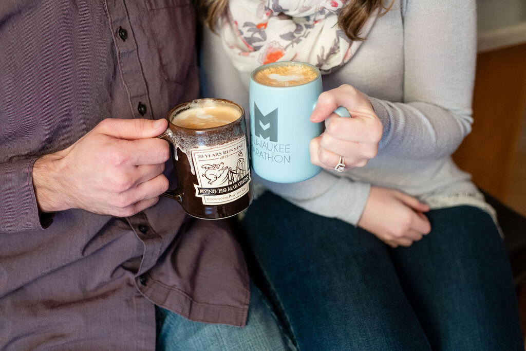 Engaged couple clinking coffee mugs together