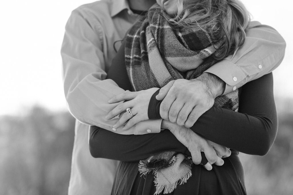 Man wraps his arms around his fiancé