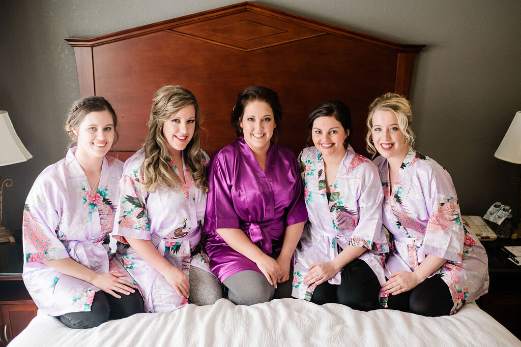 Bride and bridesmaids on hotel bed