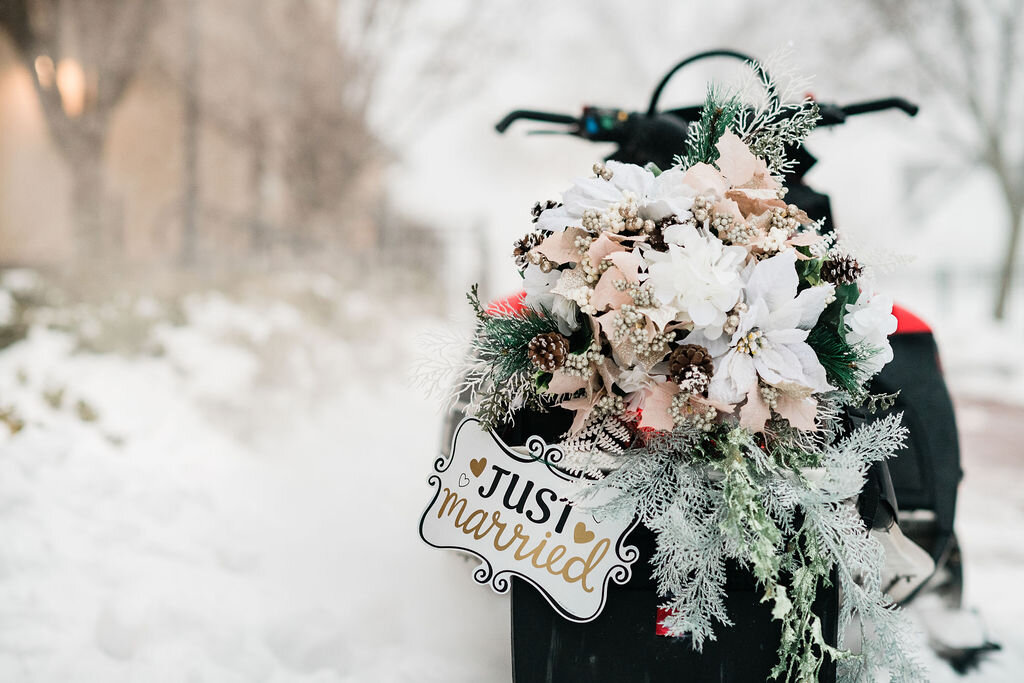 Bridal bouquet and Just Married sign on snowmobile