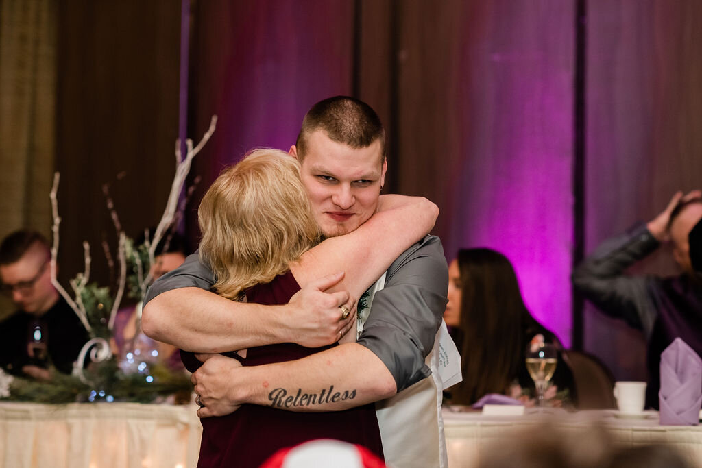 Groom hugging wedding guest