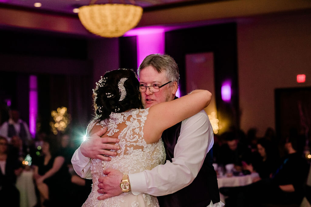 Father of the bride hugging his daughter on the dance floor