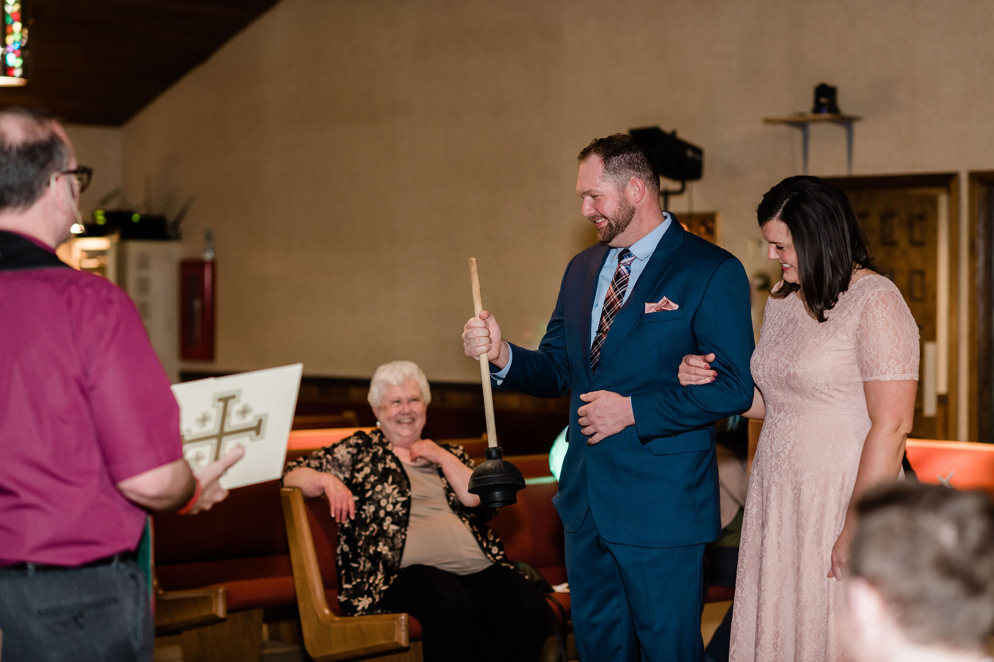 Groom holding a plunger in church