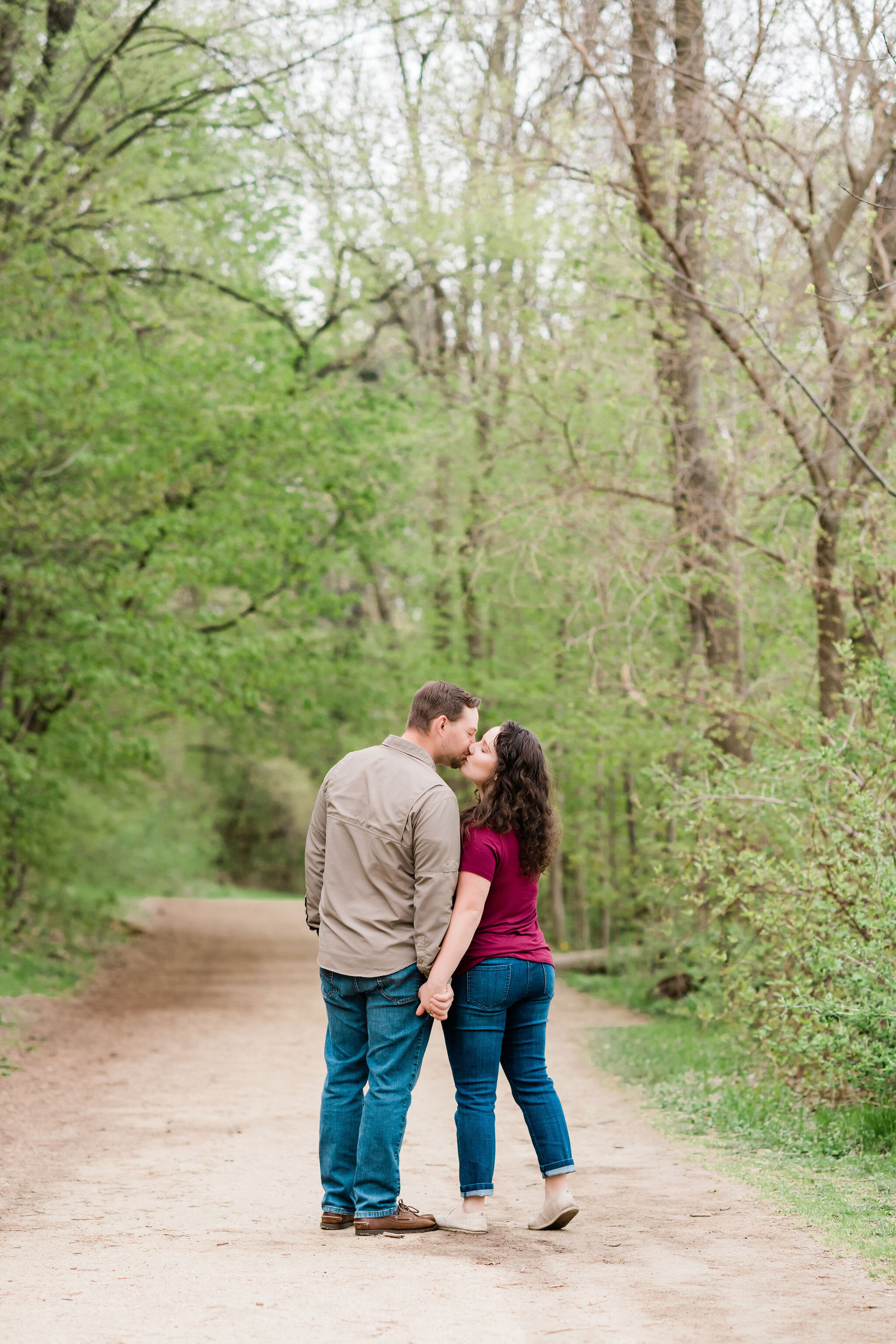 Couple kissing on a path in the woods
