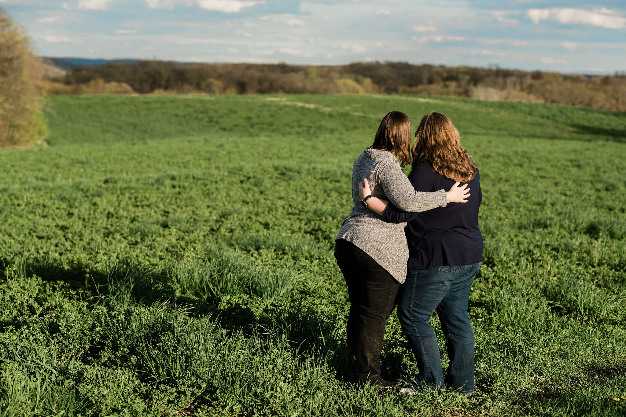 Engaged lesbian couple taking in the farm scenery