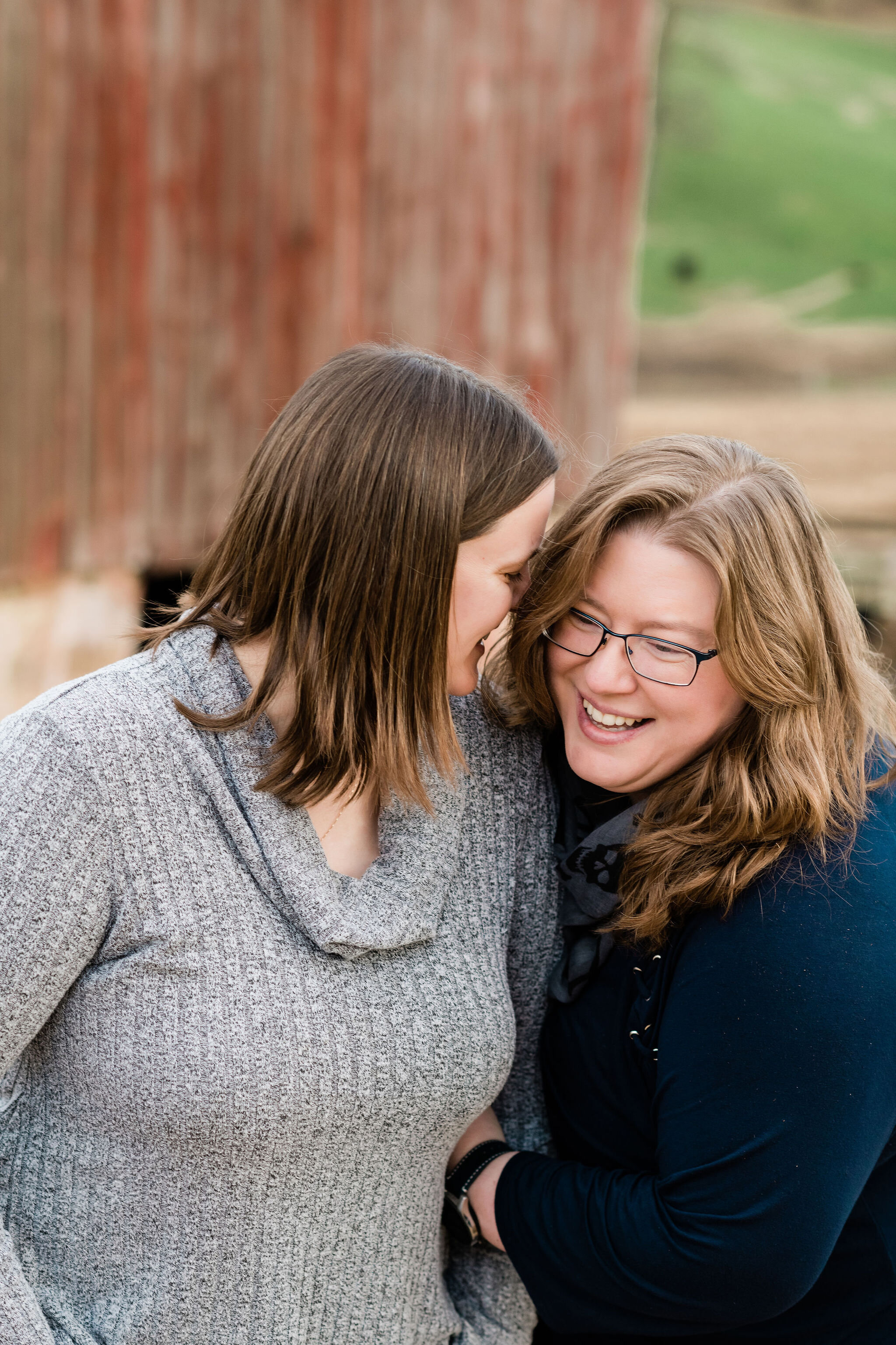 Woman whispers into her wife's ear