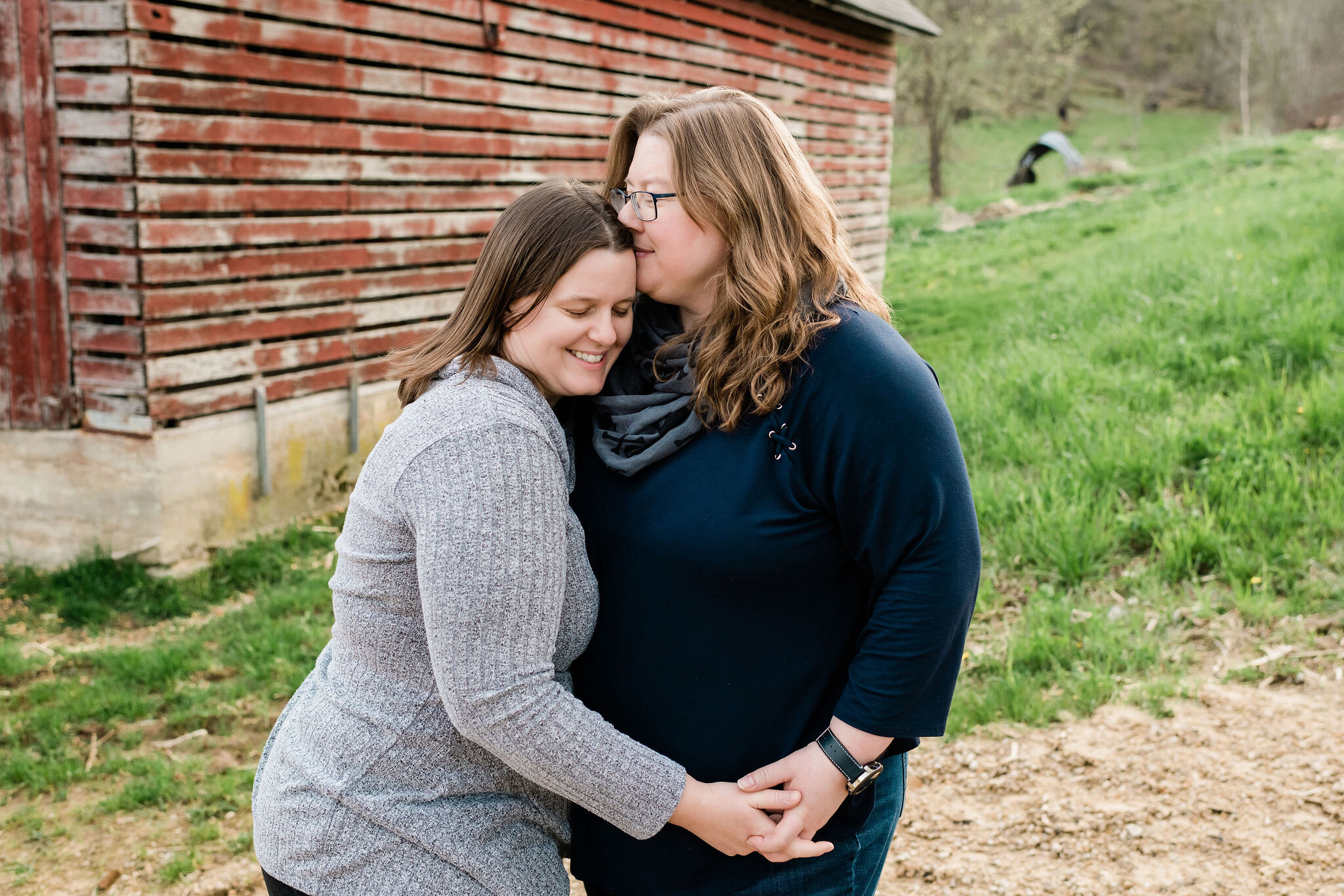 Woman kisses the top of her wife's head