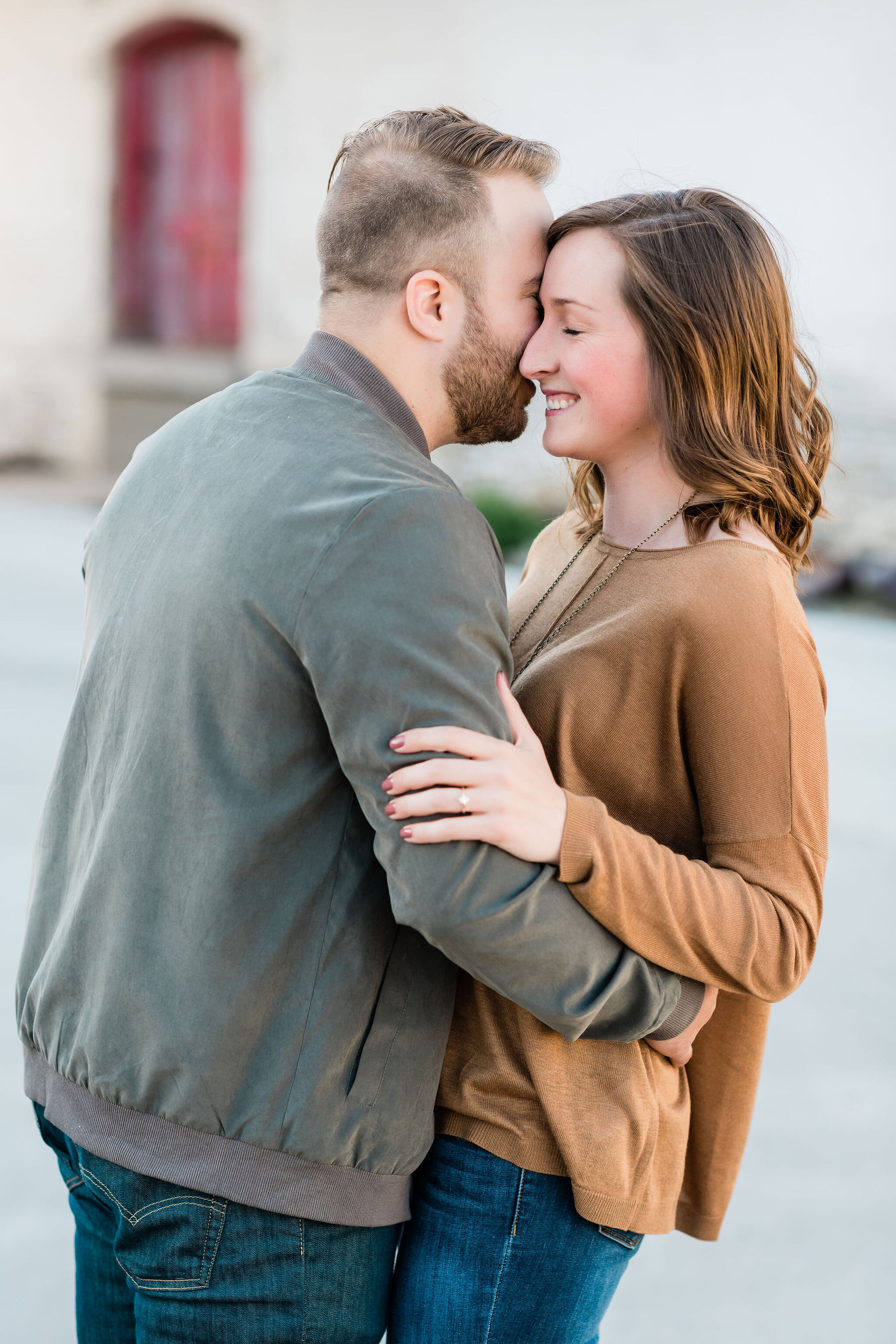 Man kissing fiancé's cheek