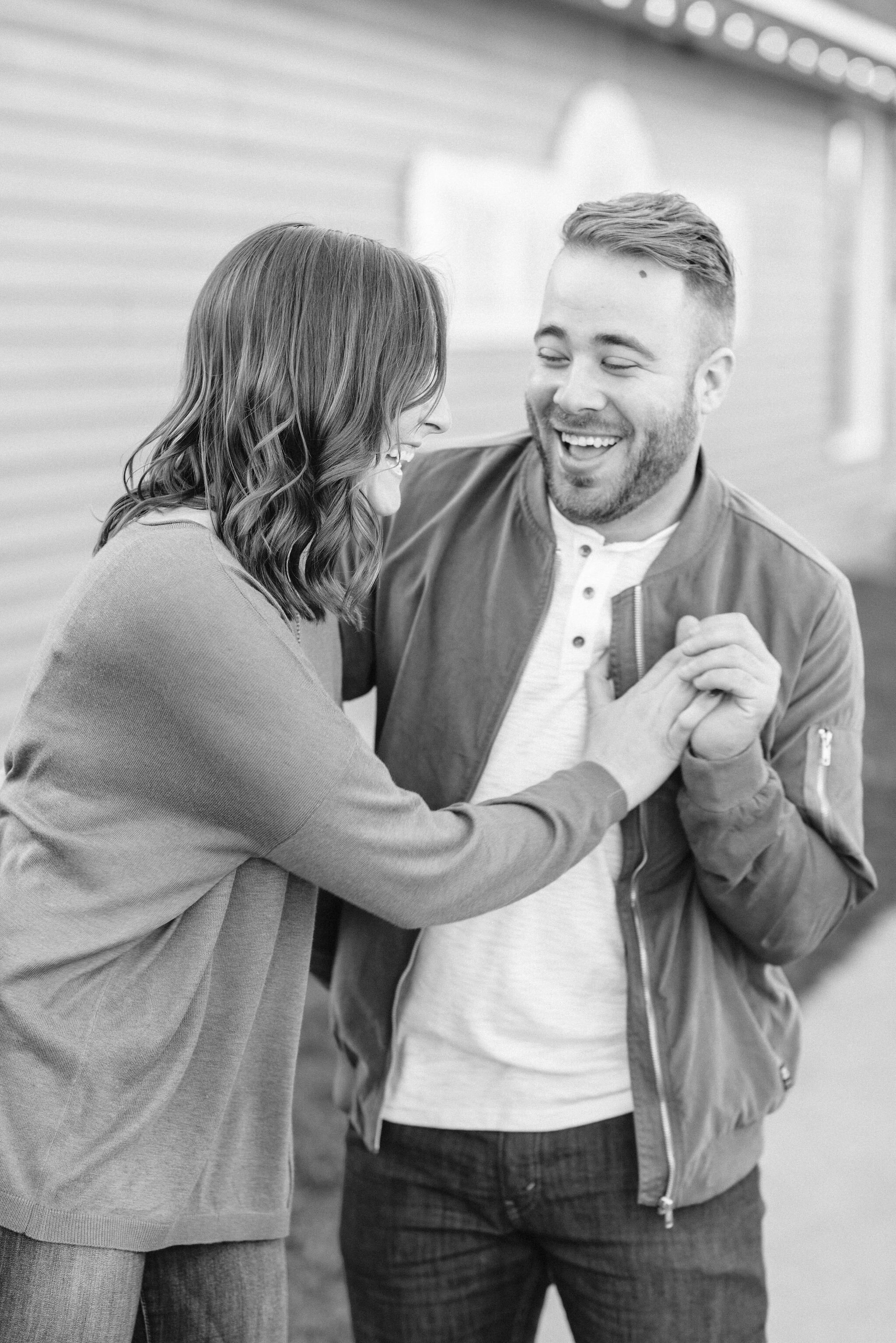 Engaged couple holding hands and laughing