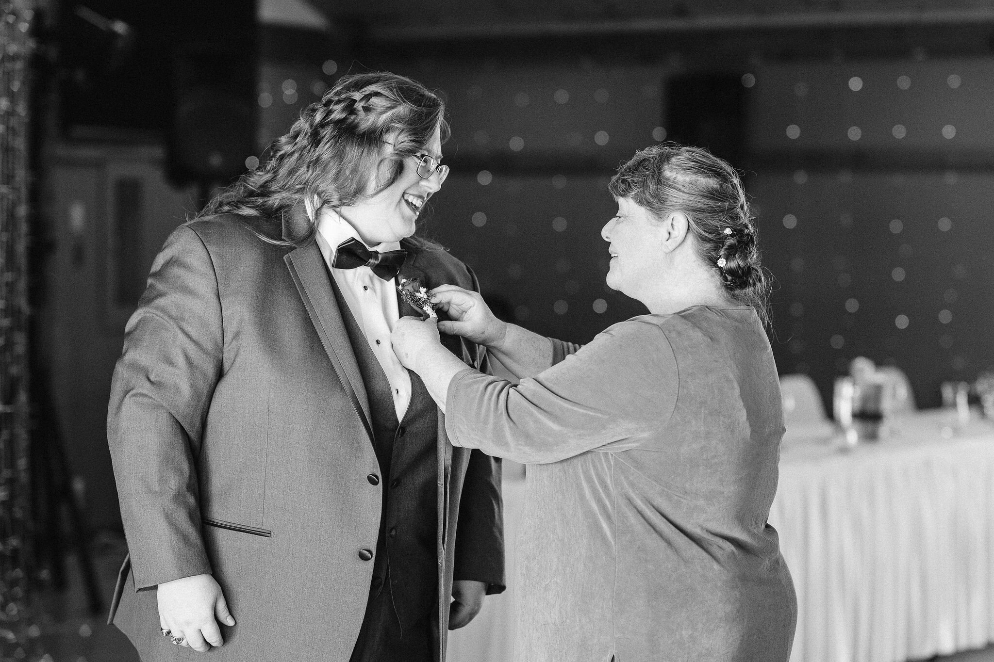 Mother of the bride pins on her daughter's boutonniere