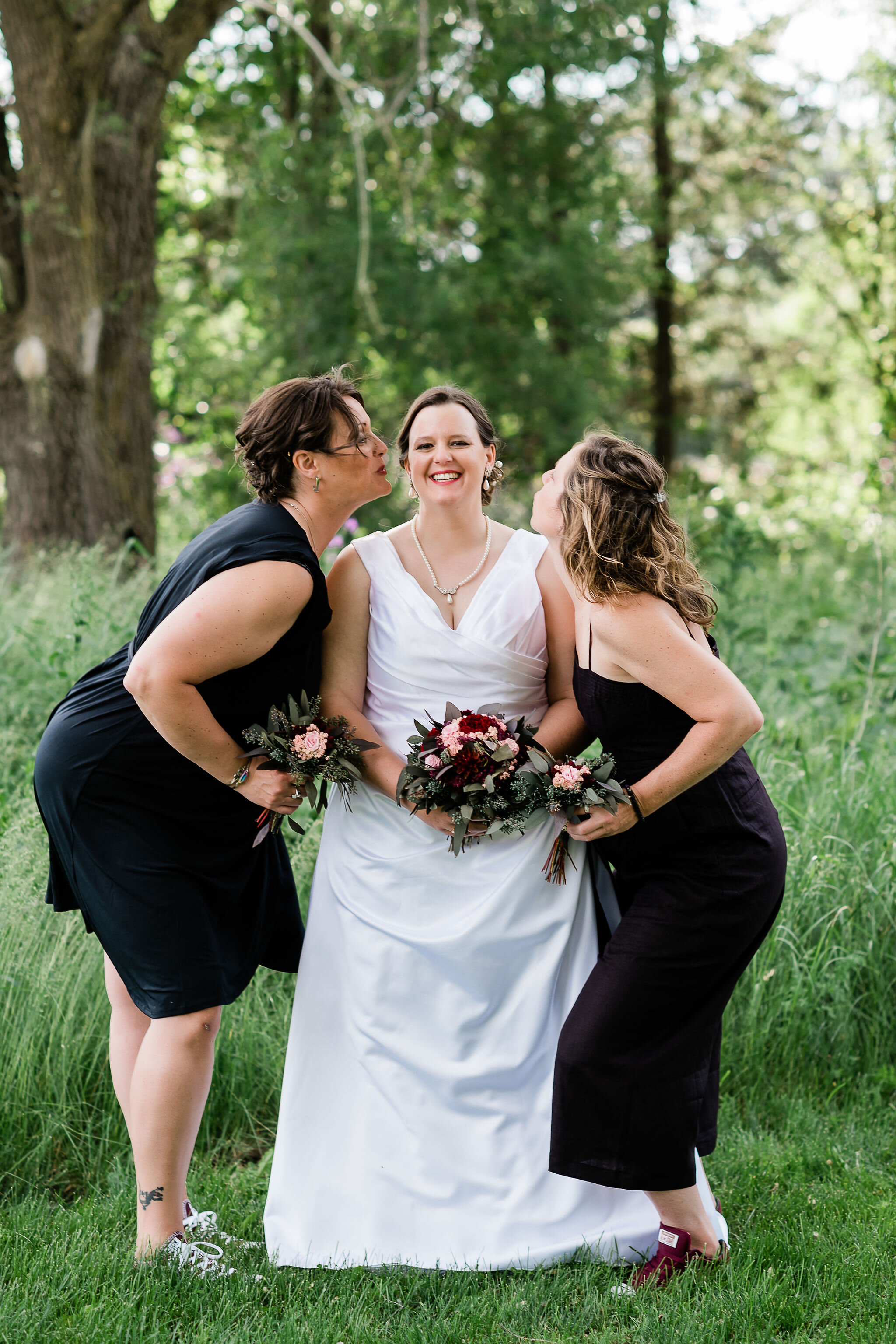 Bridesmaids kissing bride