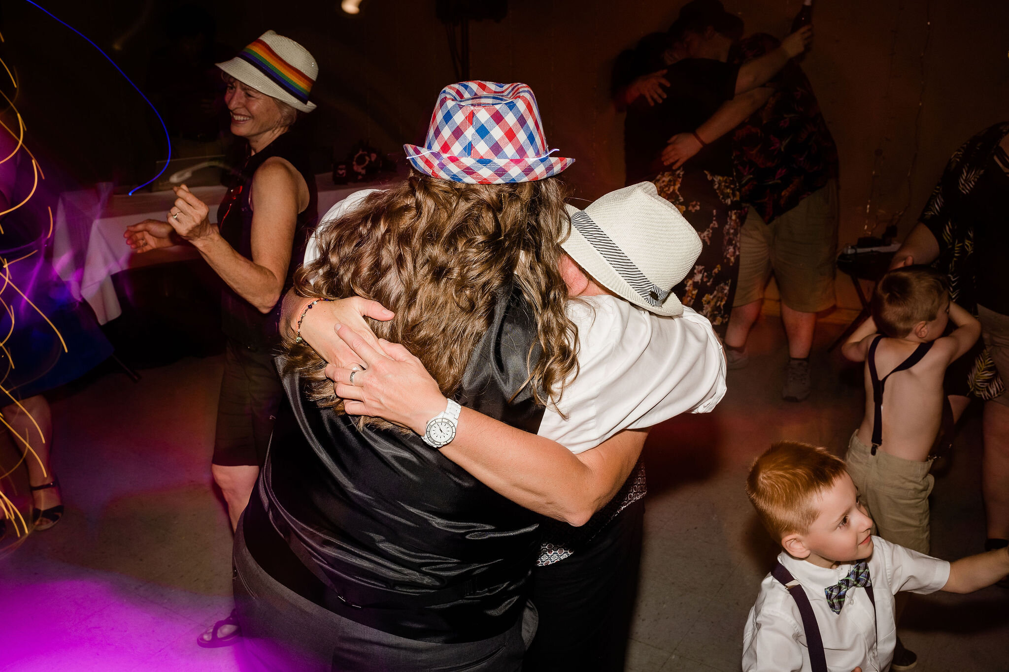 Bride and wedding guest hugging on the dance floor