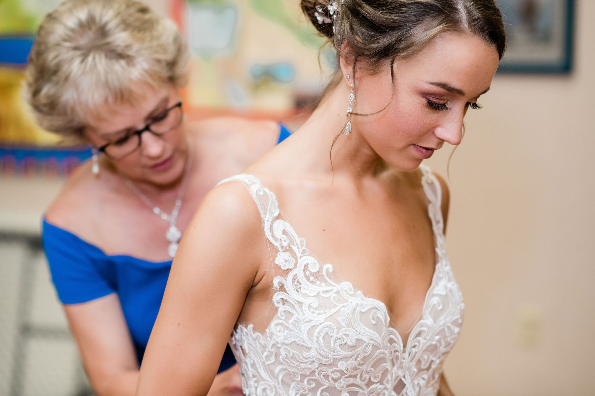 Mother of the bride buttoning up wedding dress