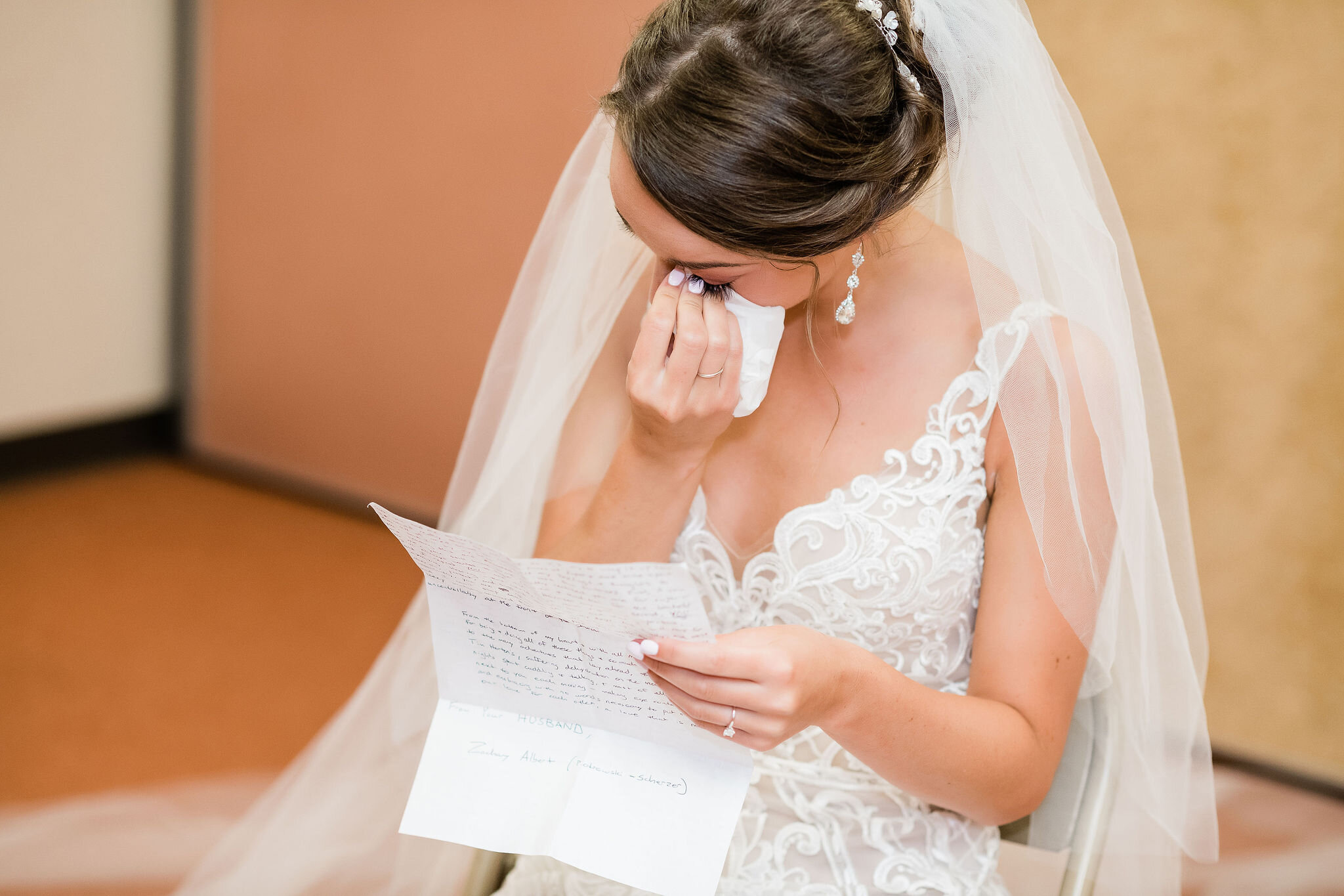 Bride wipes away tears as she reads a letter from the groom