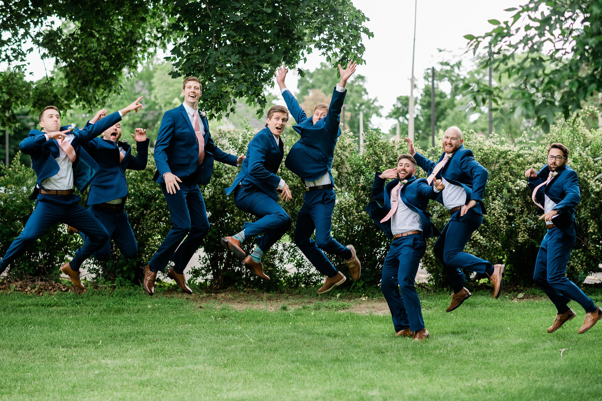 Groom and groomsmen jumping
