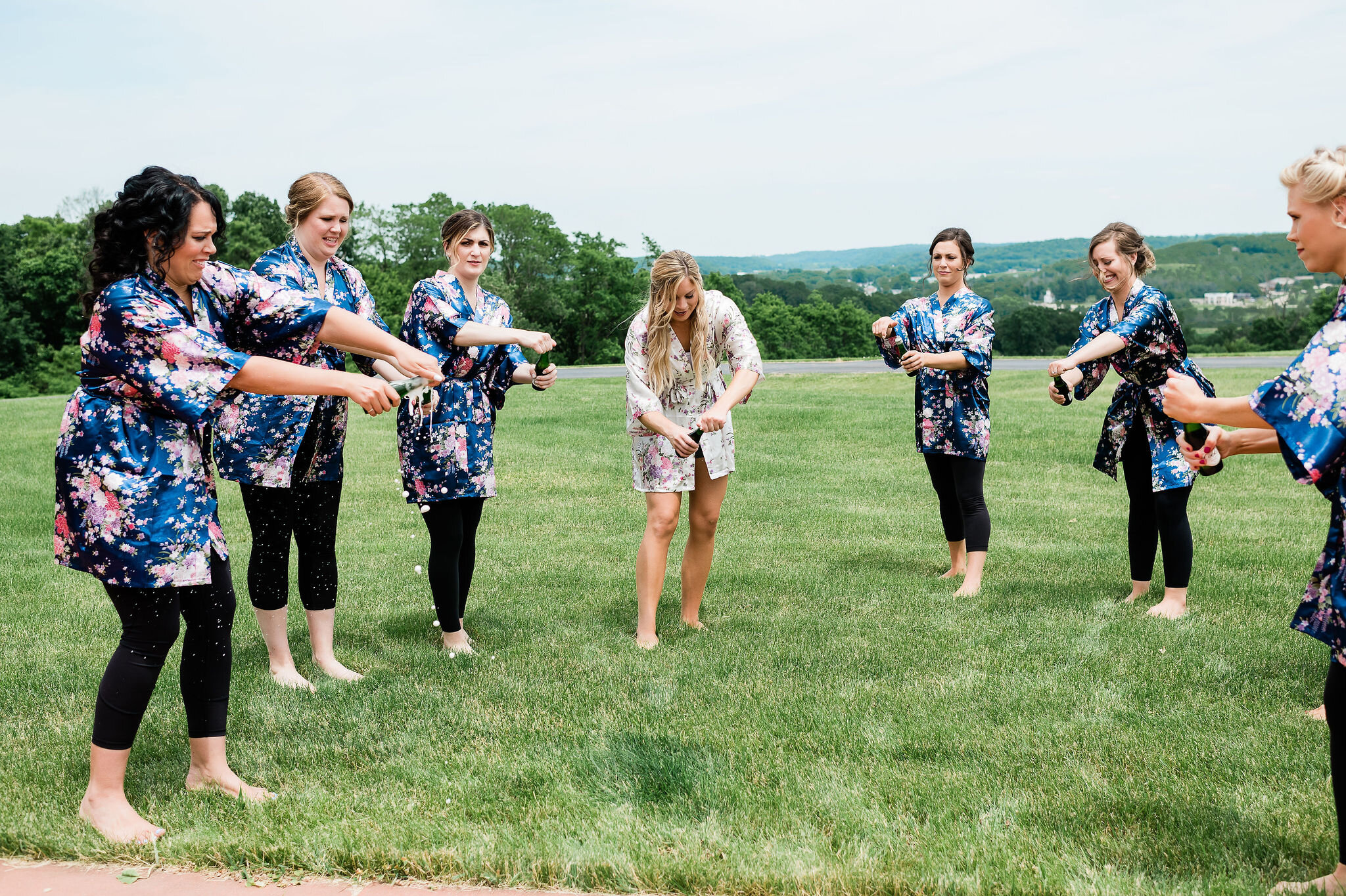 Bride and bridesmaids opening personal bottles of champagne