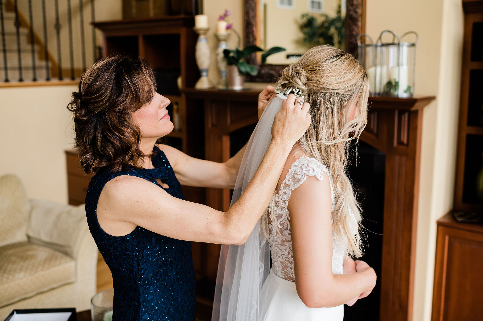 Mother of the bride putting bride's veil in