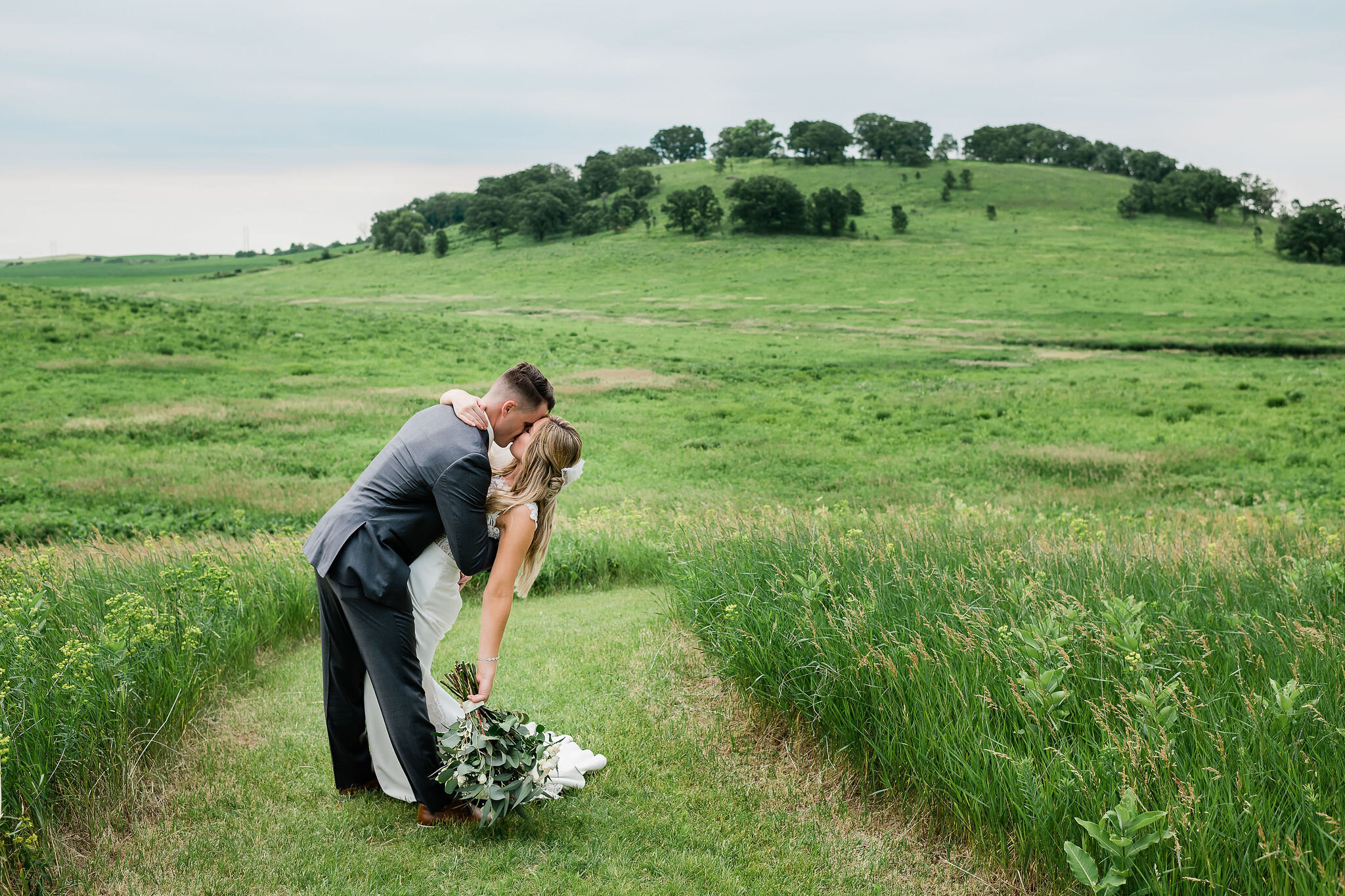 Groom dips bride back and kisses her