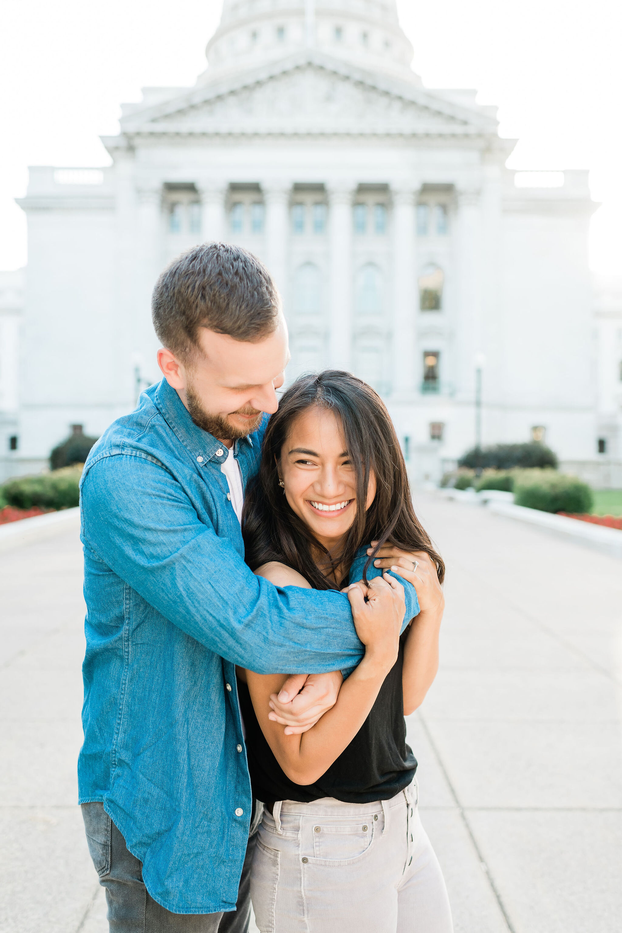 Man hugging his fiancé from behind