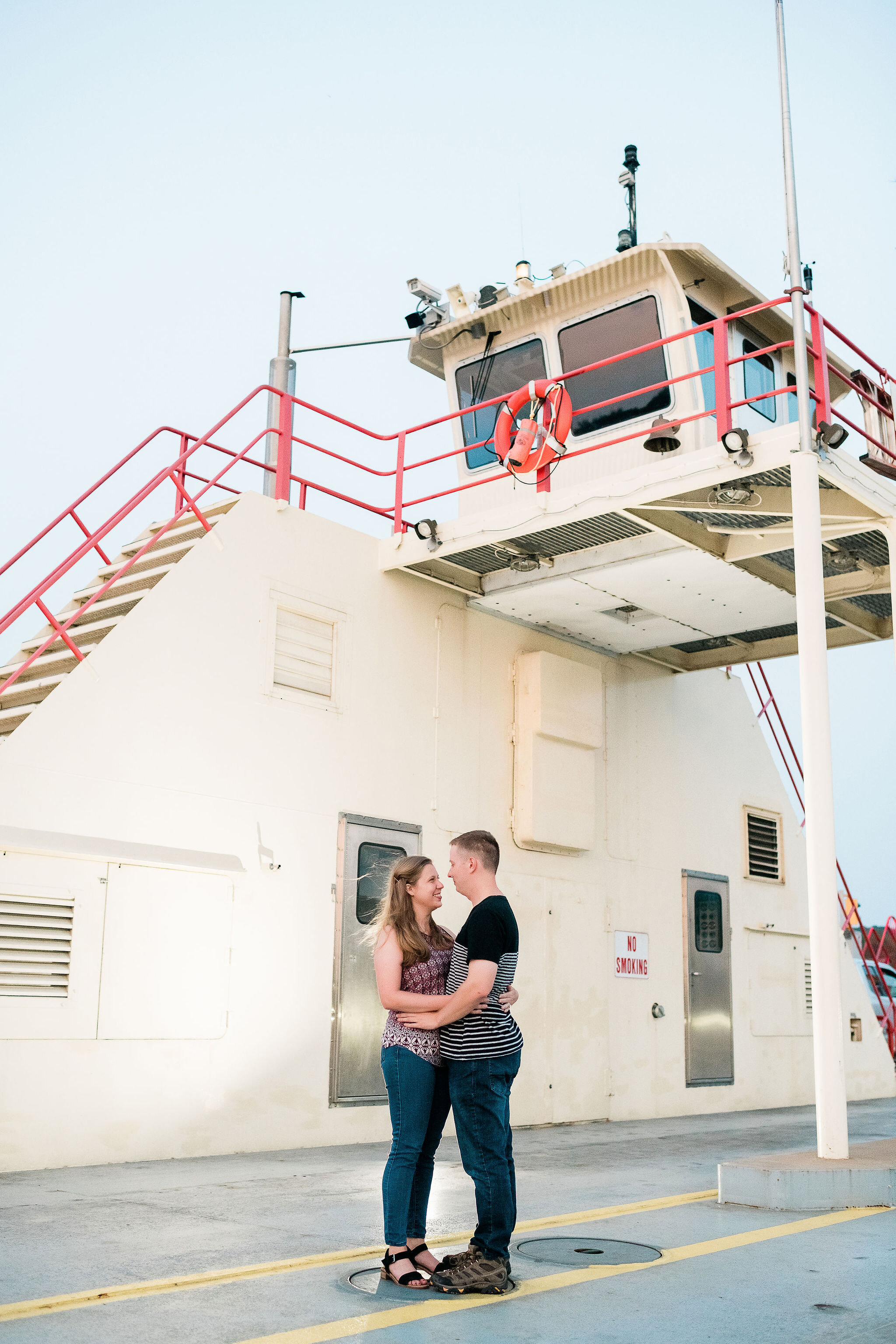 Engaged couple holding each other on the Merrimac Ferry in Merrimac, WI