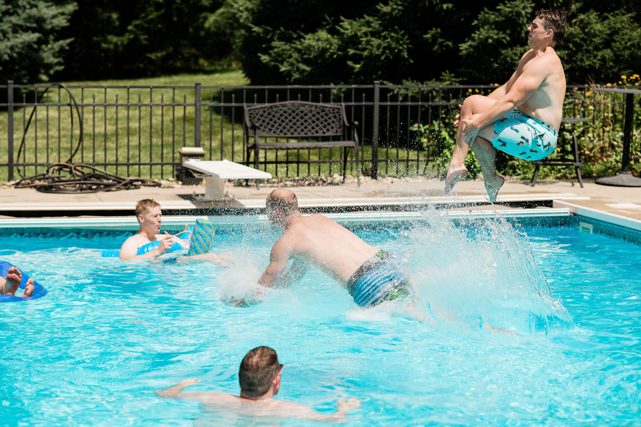 Groomsmen jumping into the pool