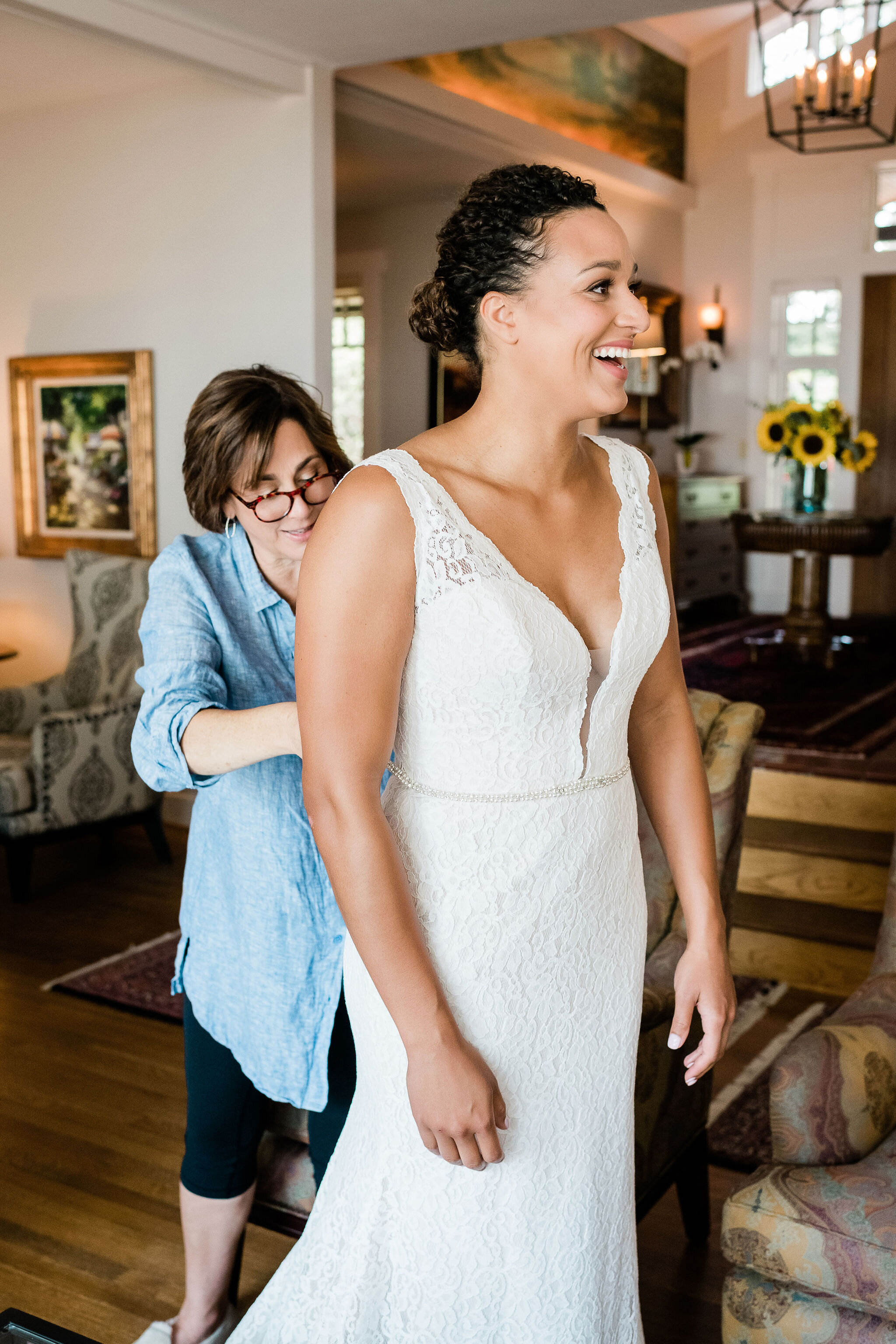 Bride's mom buttoning up bride's dress