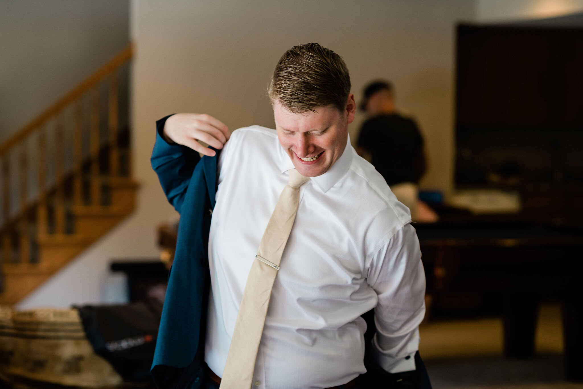 Groom putting on his suit jacket