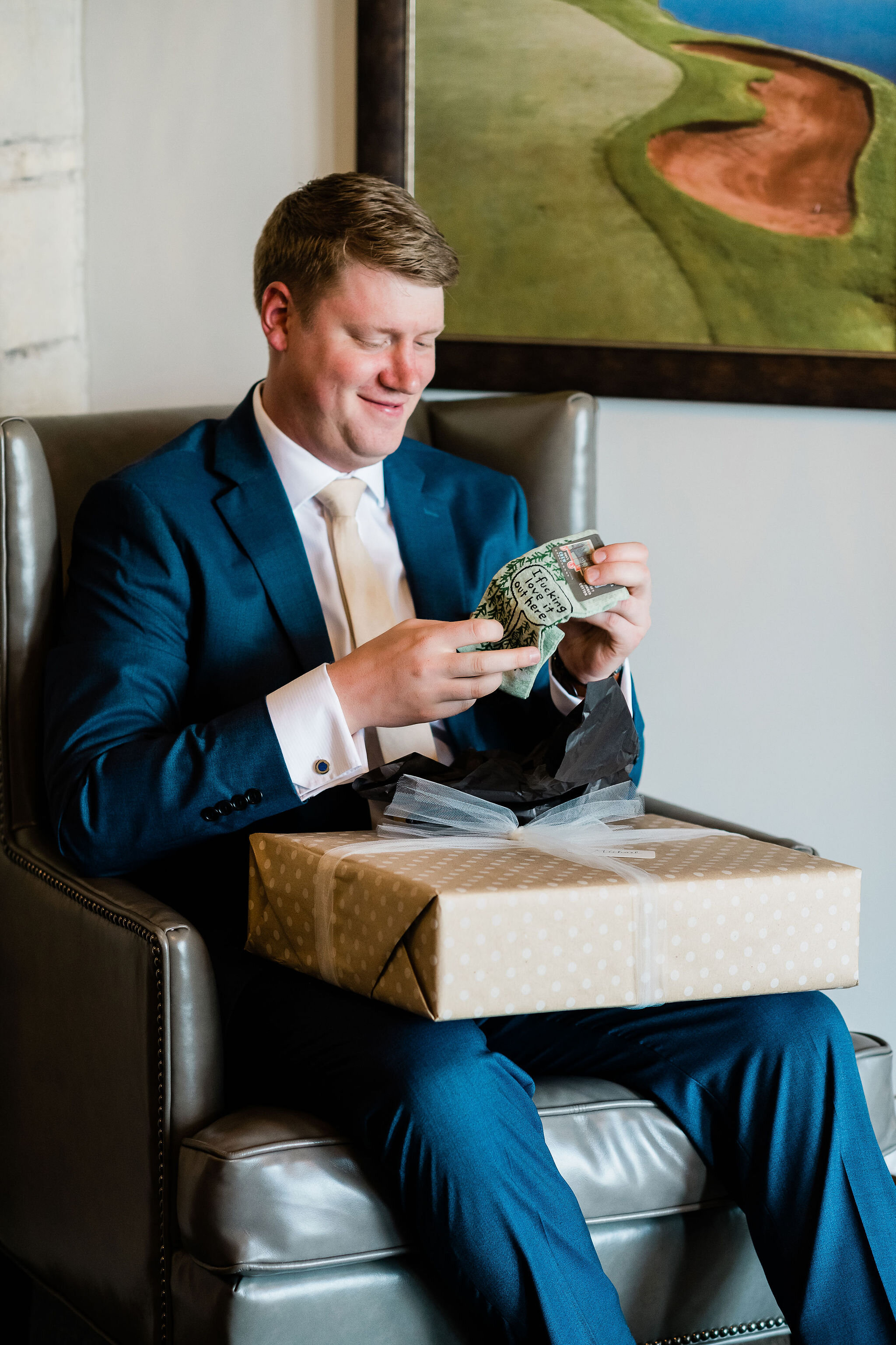Groom opening up a gift from the bride