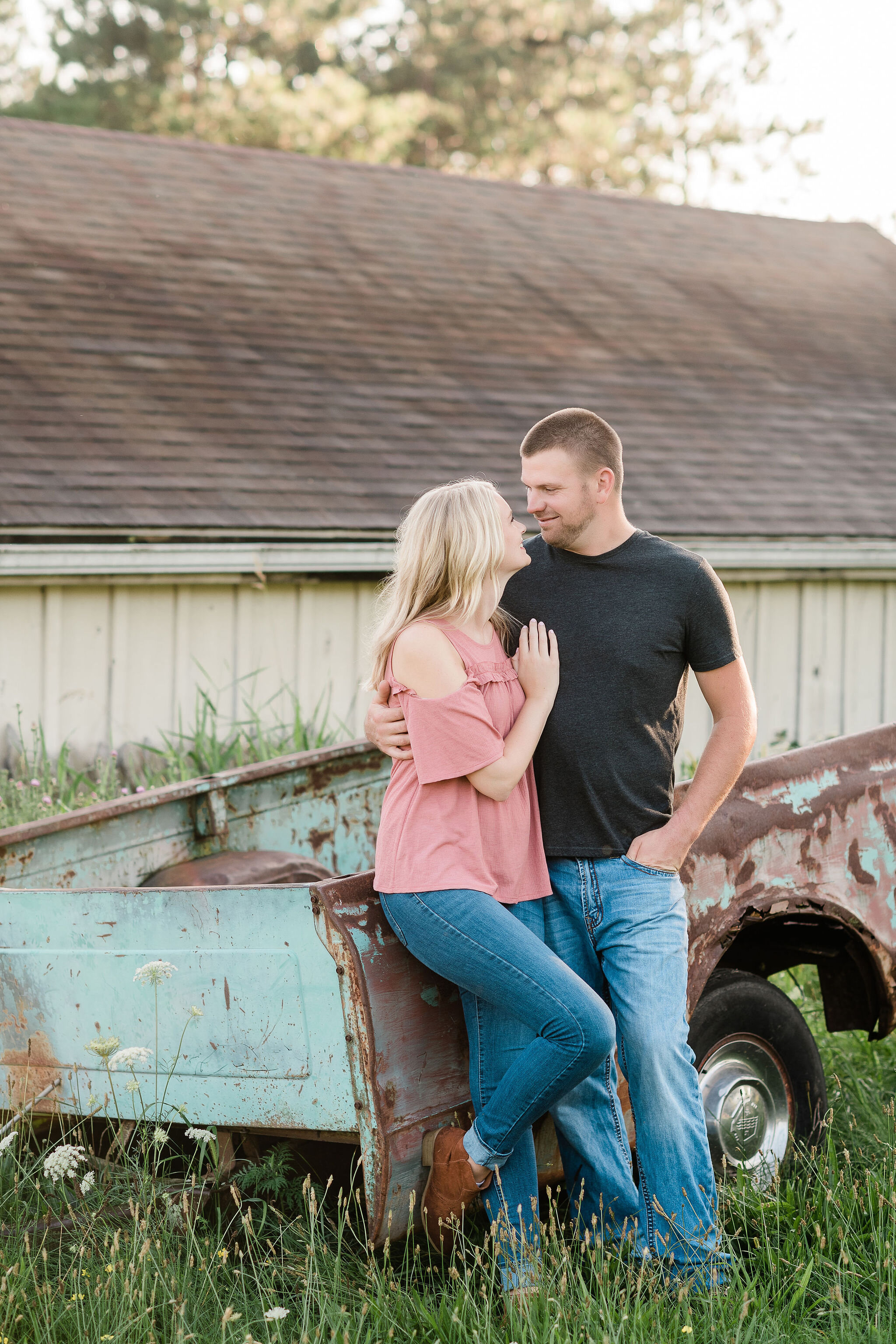 Engaged couple in front of an old blue truck