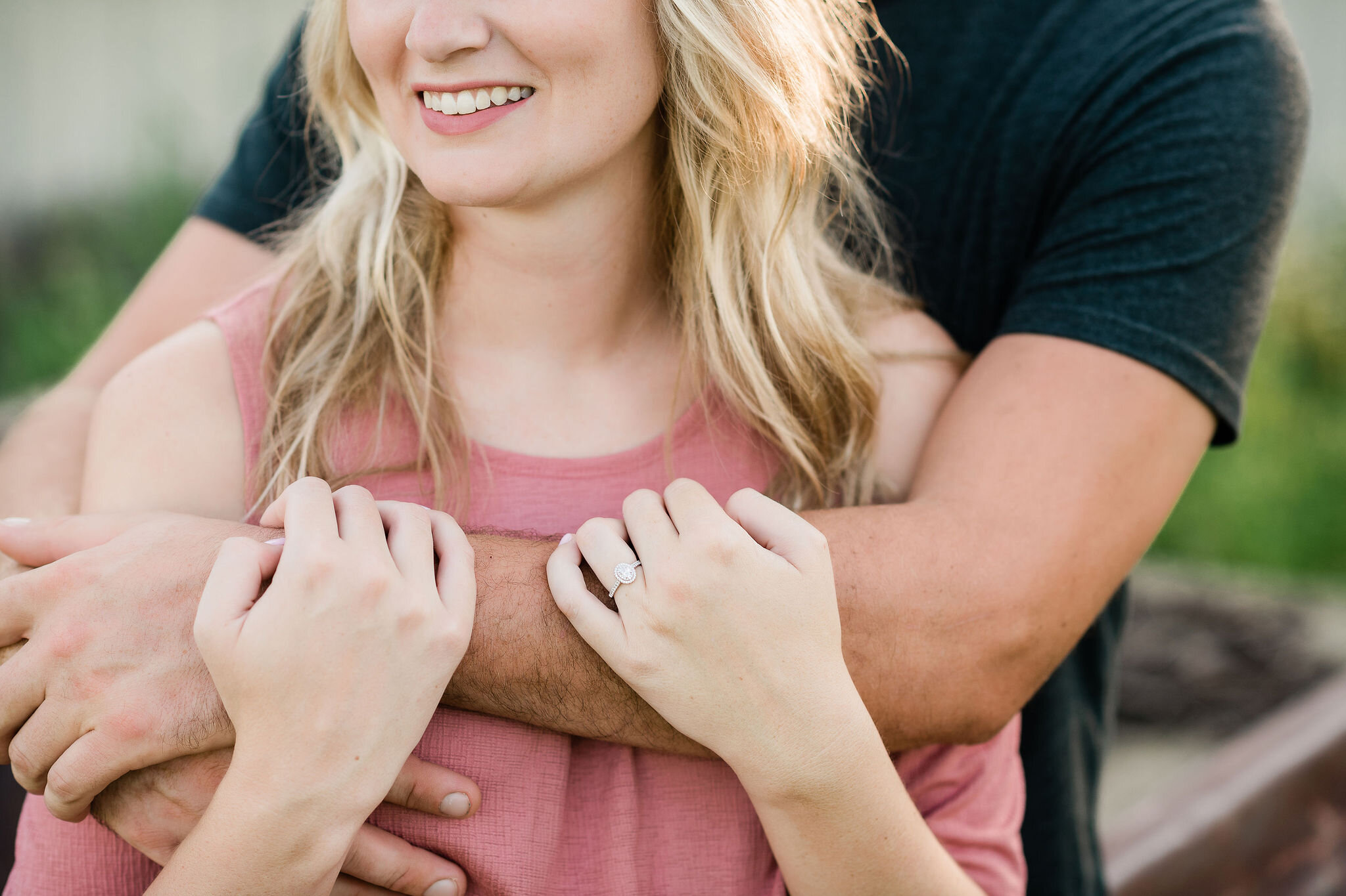 Man wraps his arms around his fiancé