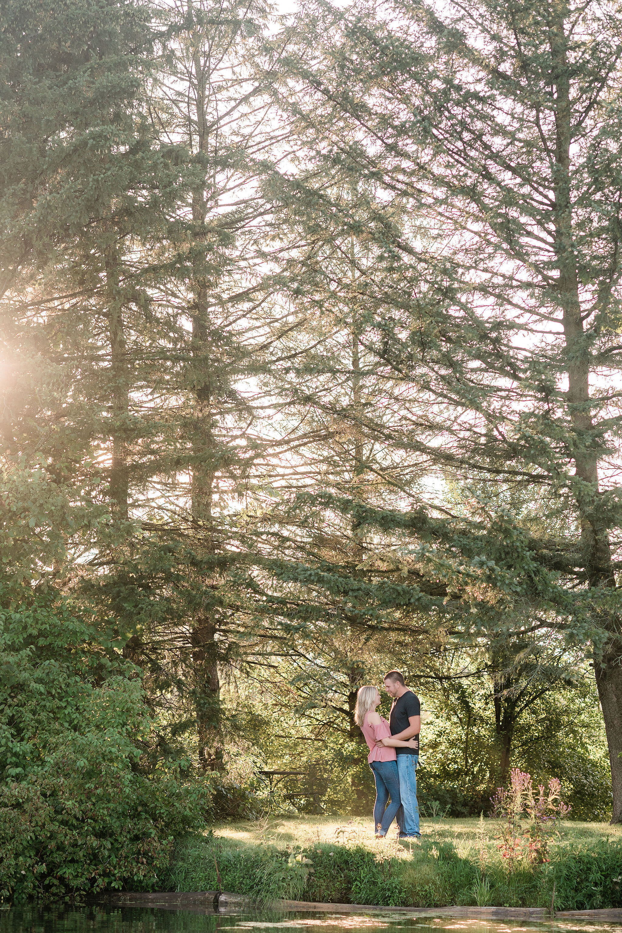 Engaged couple slow dancing by some trees
