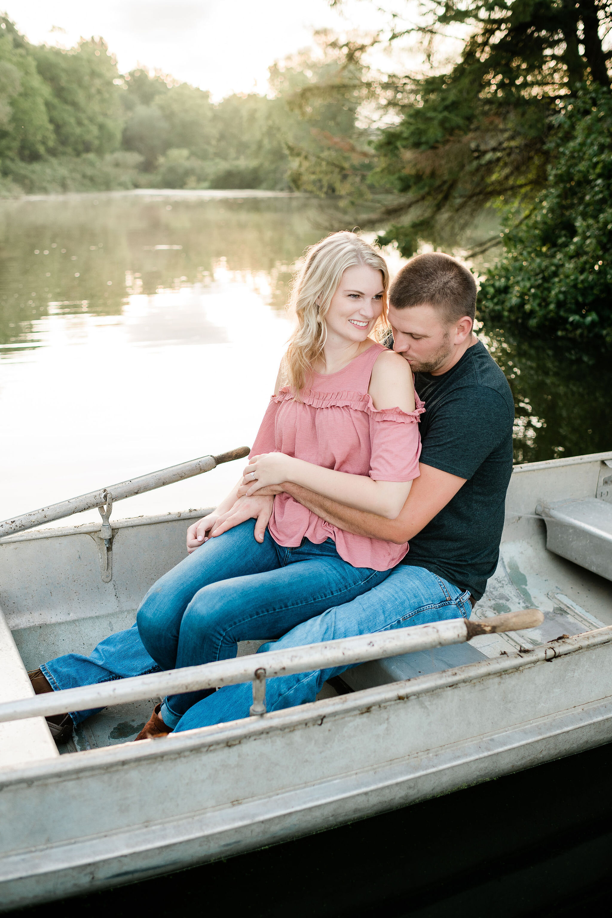 Engaged couple snuggled up in a canoe