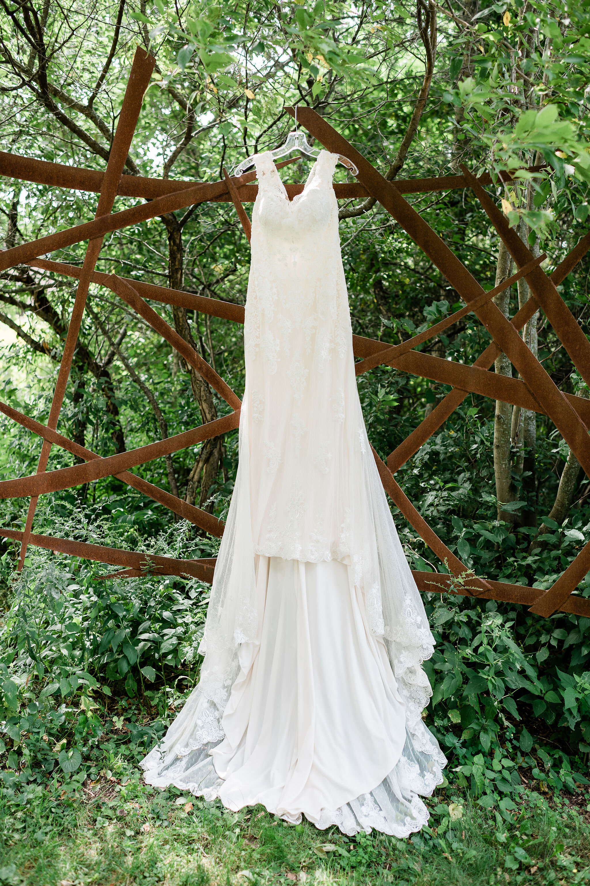 Wedding dress hanging from a garden sculpture