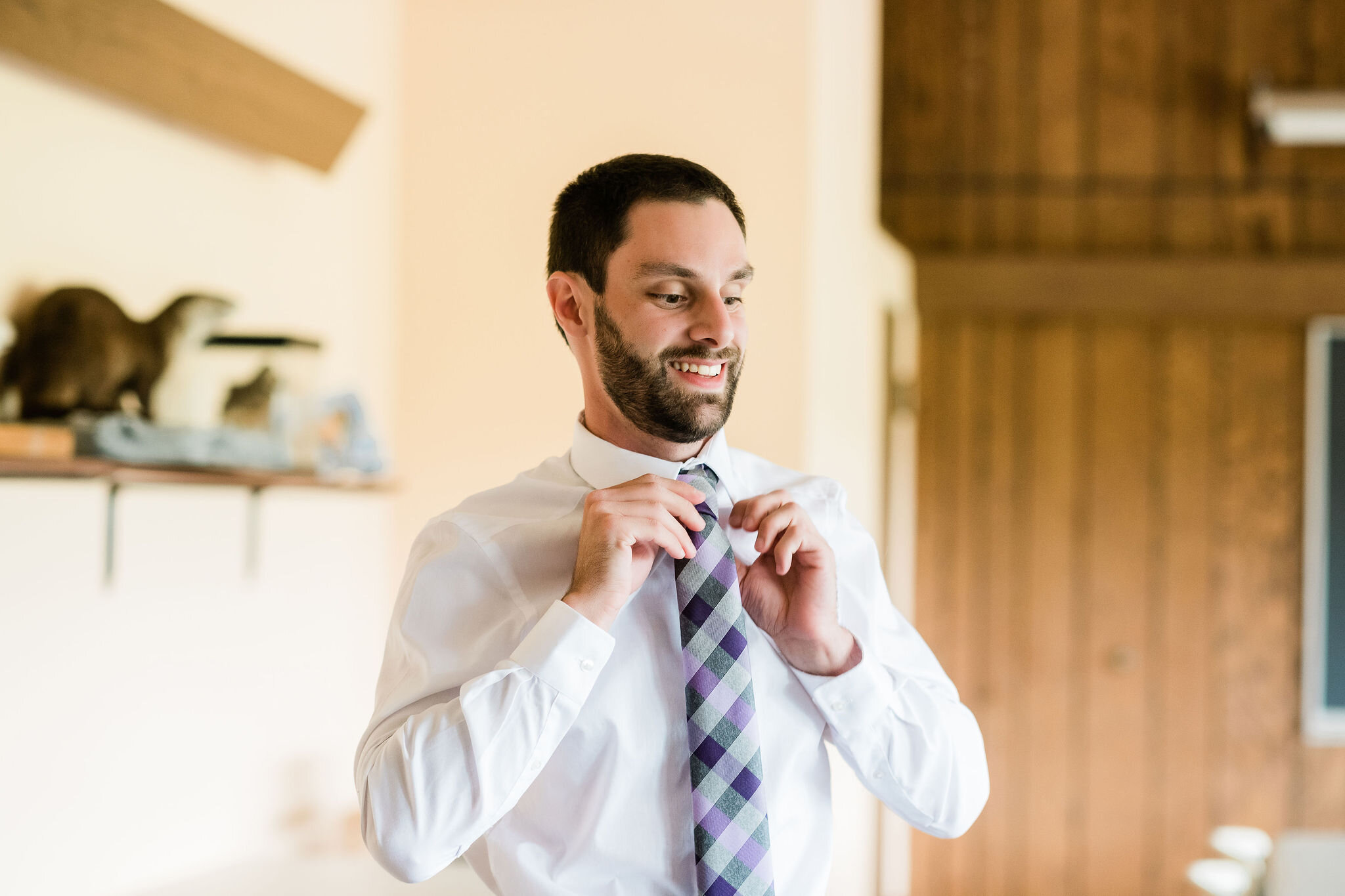 Groom putting his tie on