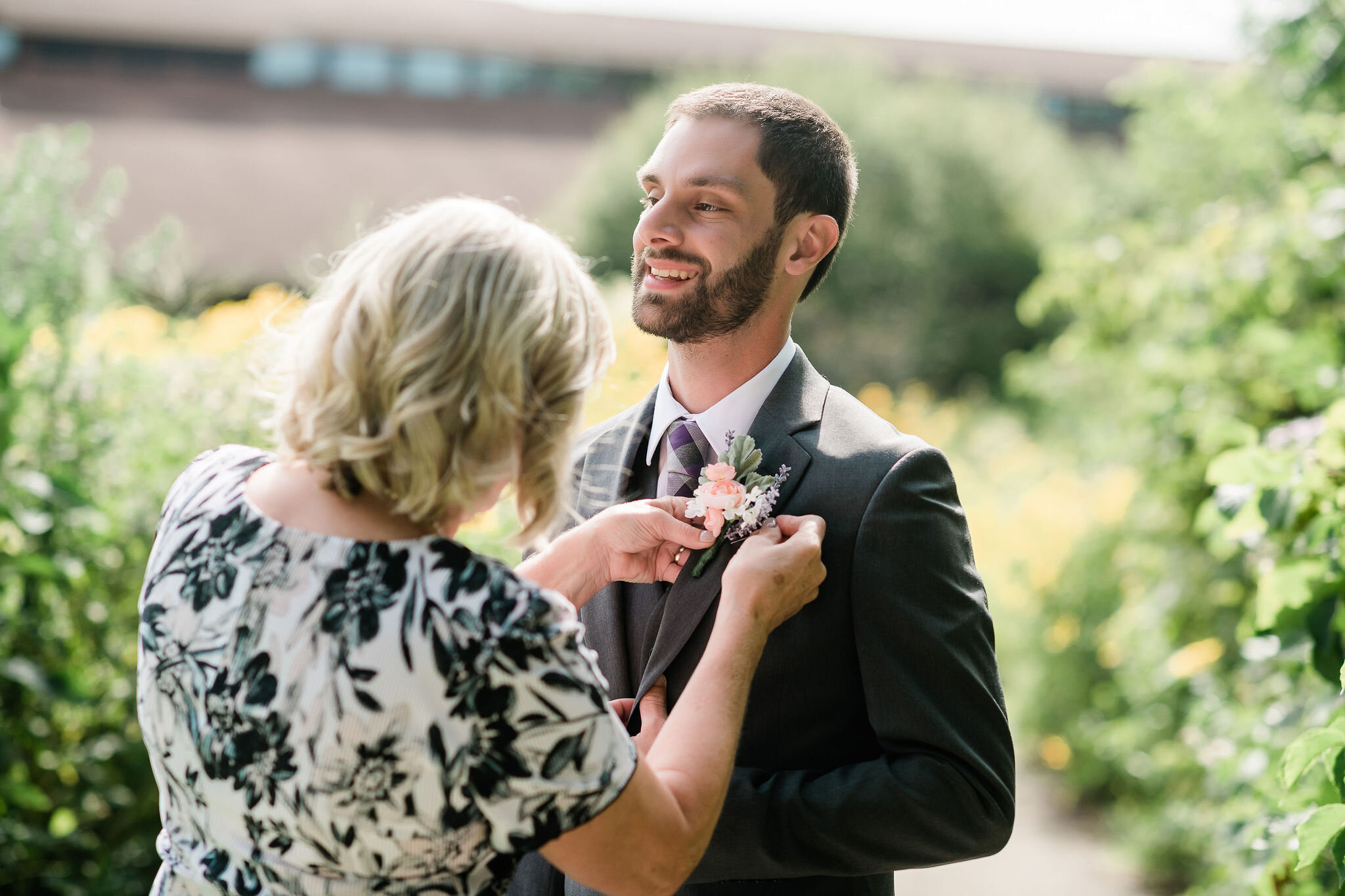 Mother of the groom pinning on his boutonniere