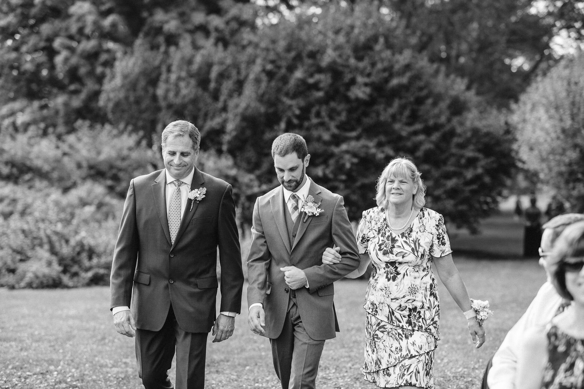 Groom walking down the aisle with his parents