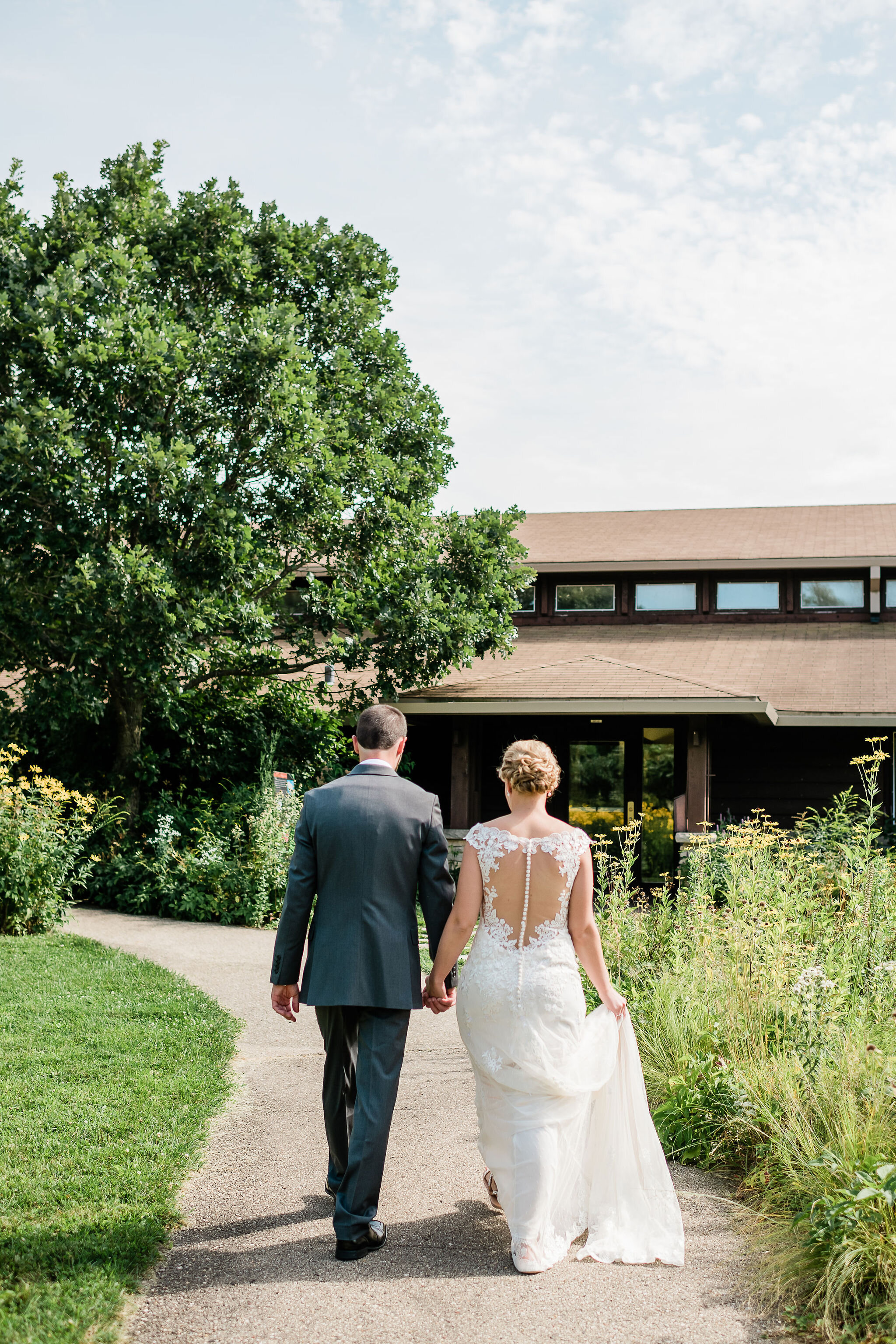 View from behind of bride and groom walking