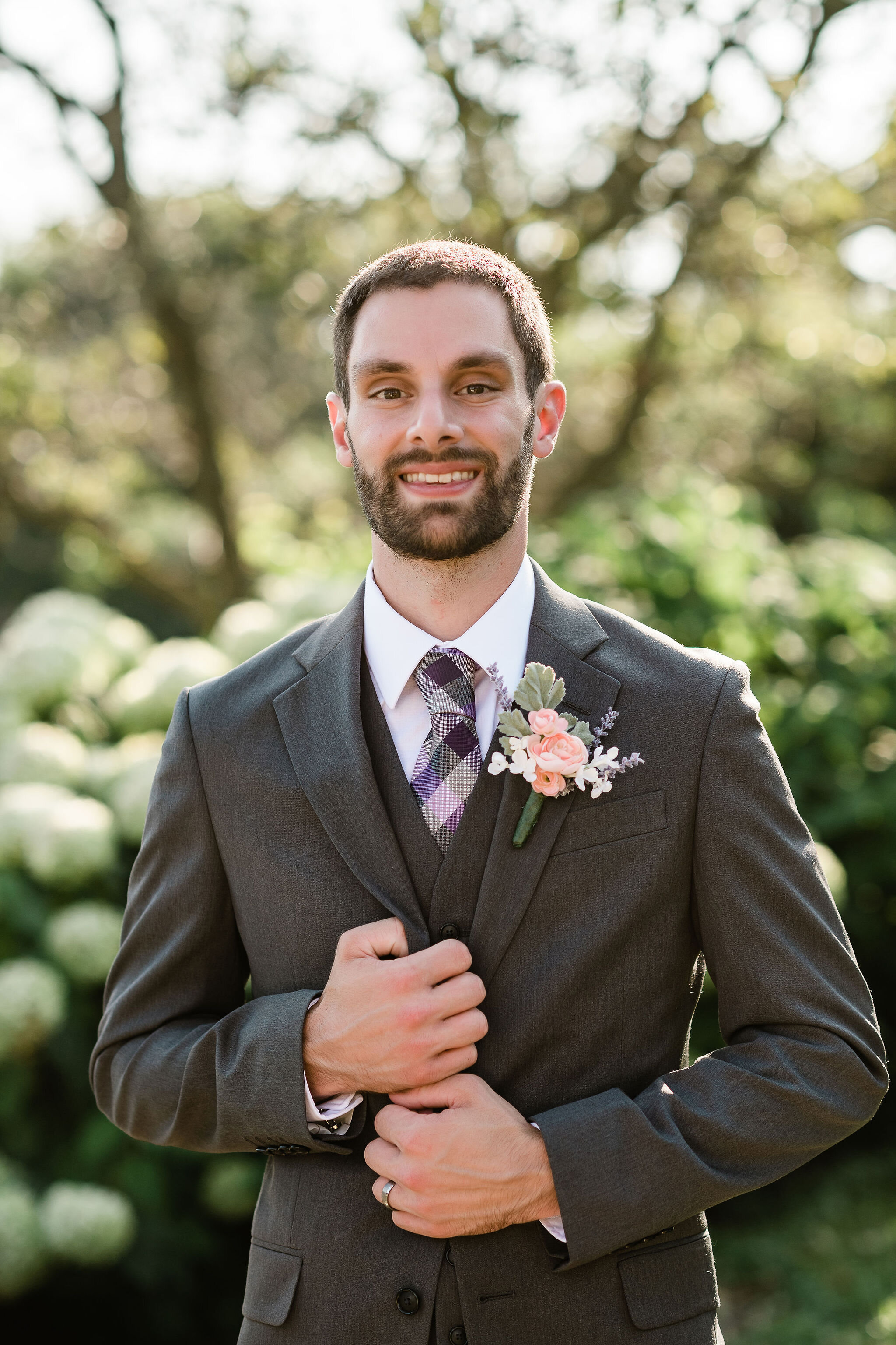 Groom holding onto his suit jacket