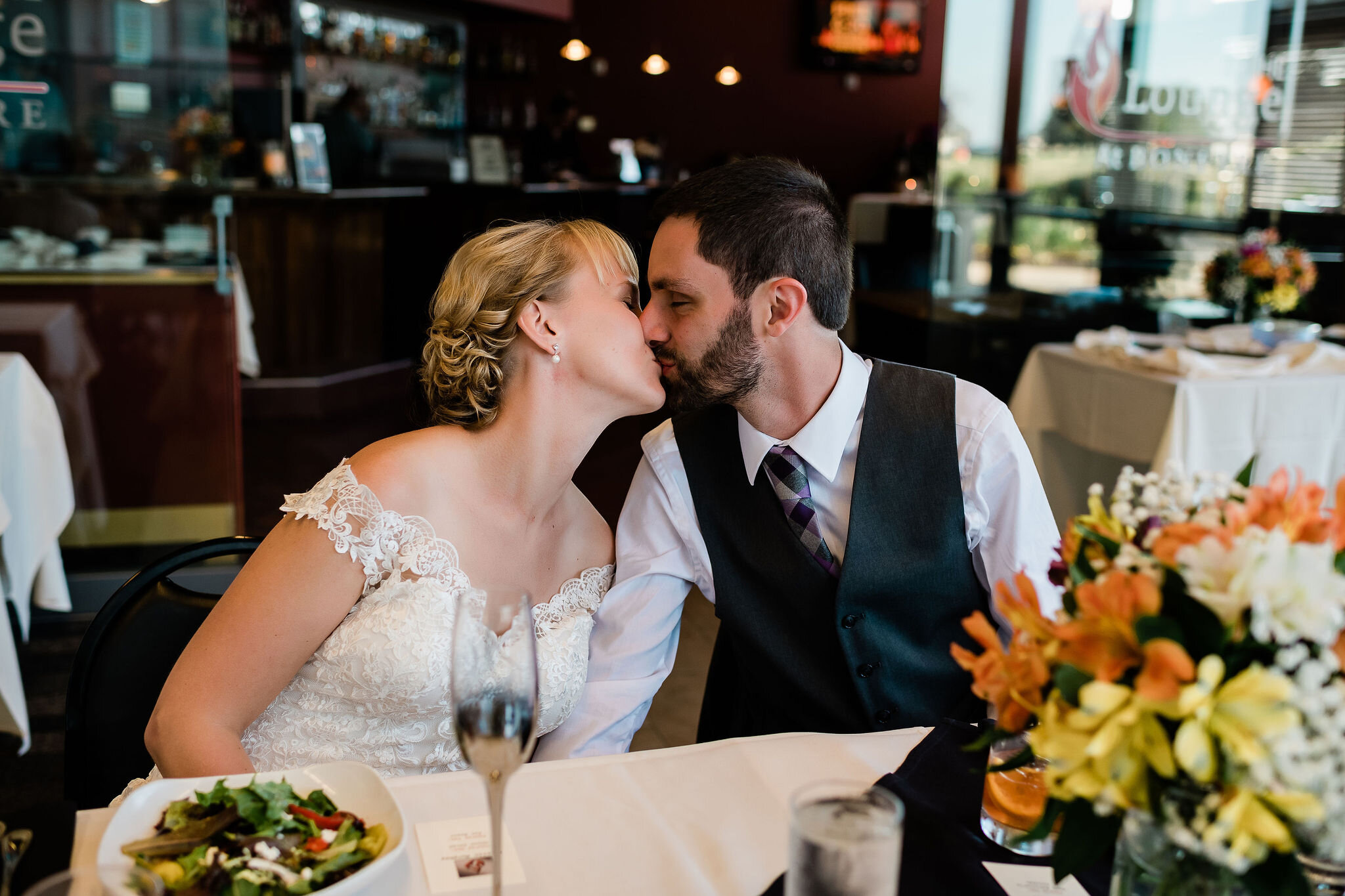 Bride and groom kissing at the table