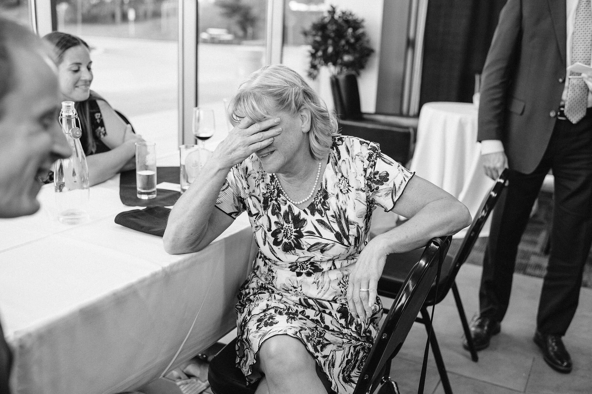 Mother of the groom holding her hand over her eyes