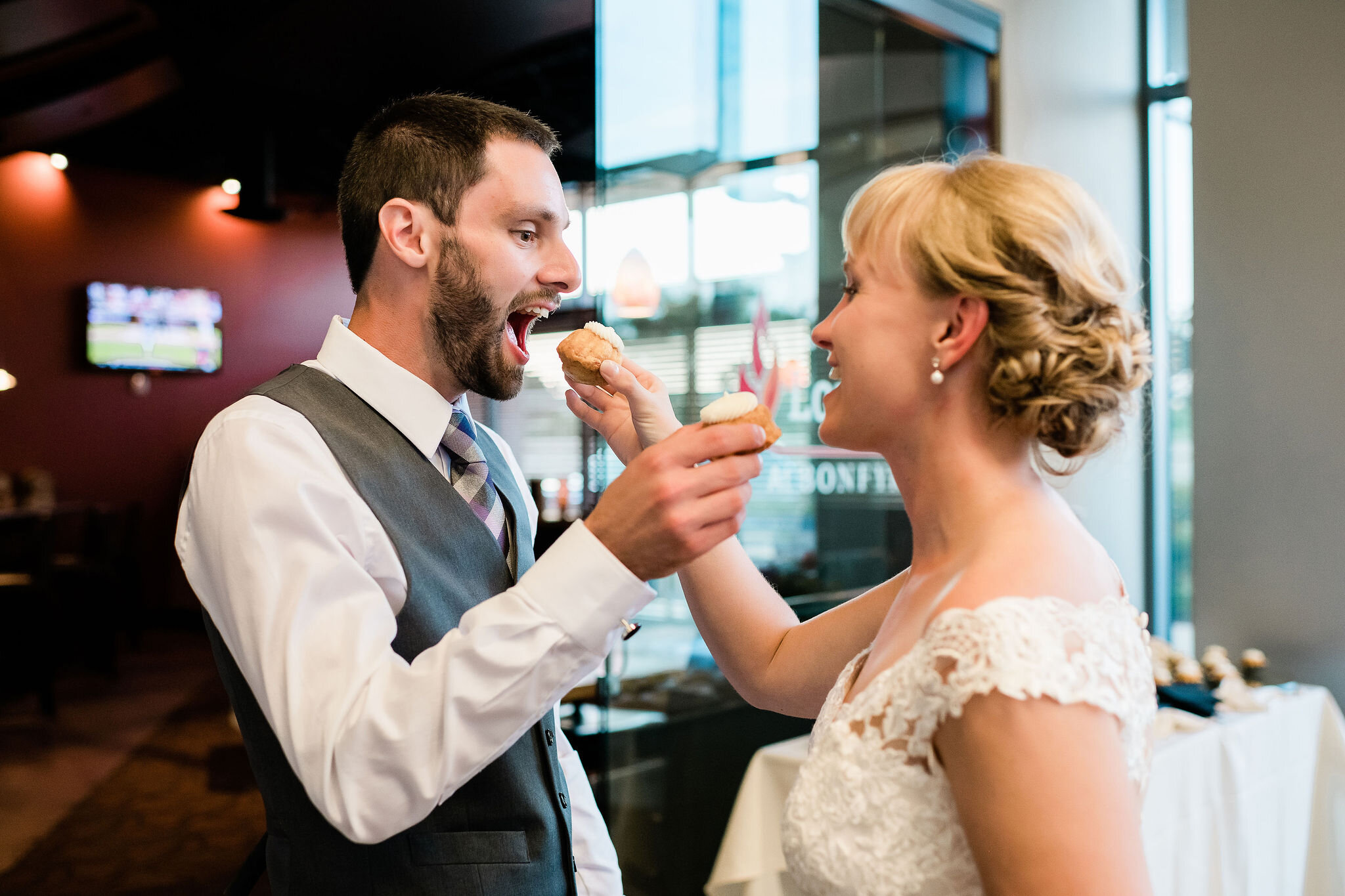 Bride and groom feeding each other cupcakes